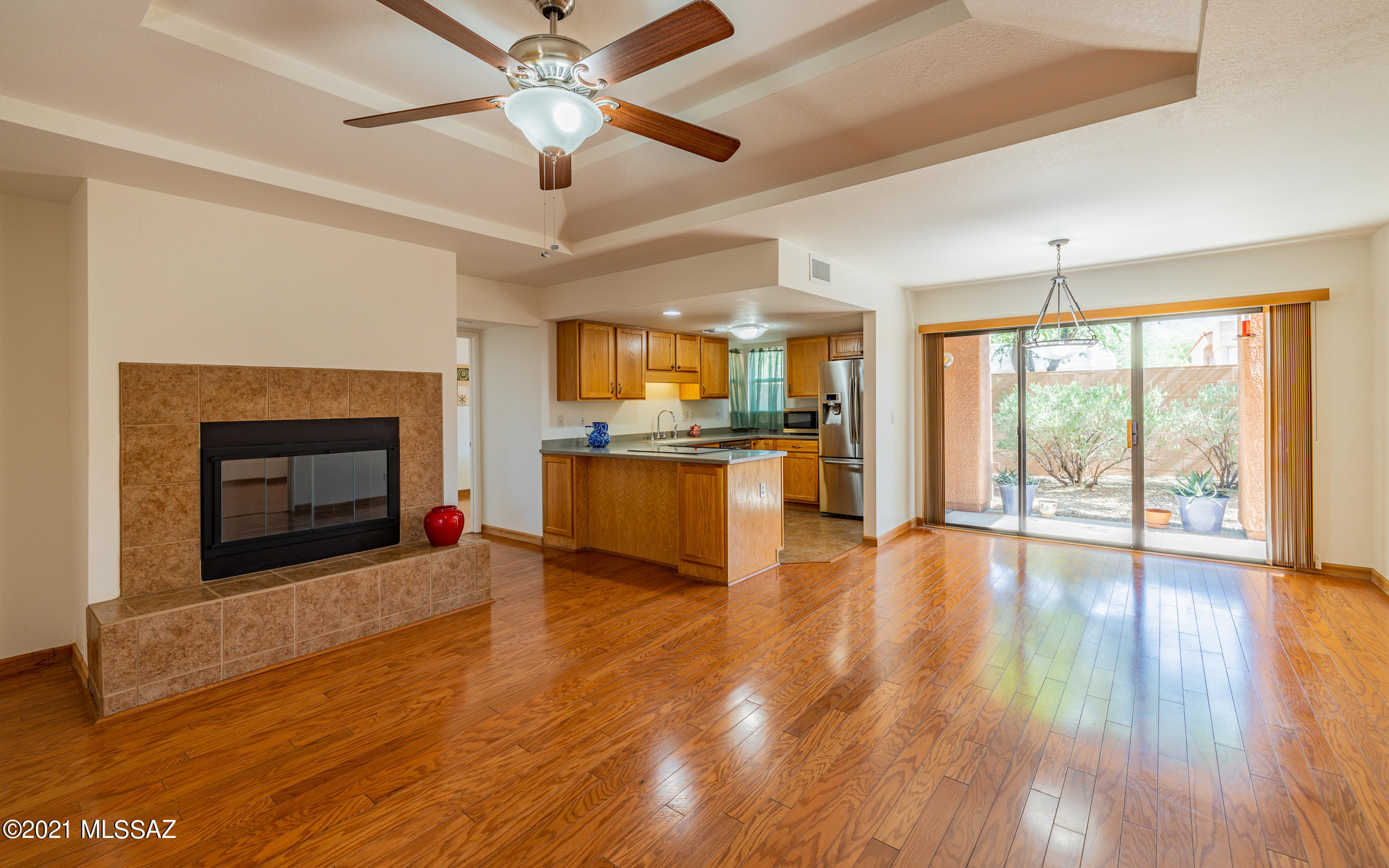 Private, lovingly maintained first floor unit with mountain views. Condo features open, split bedroom layout, zoned heating & cooling (REPLACED THIS YEAR), gorgeous engineered wood flooring w/ wood burning fireplace. Sliding glass door frames North facing patio w/GORGEOUS Catalina Mountain views & abundant natural desert landscaping. Kitchen includes Corian counters & newer refrigerator. Lots of storage, walk in closet and ceiling fans. HOA includes a heated salt water pool, 2 spas, clubhouse, tennis & pickle ball court, gas bbq grills, exercise facility AND all this just South of Sabino Canyon Park!