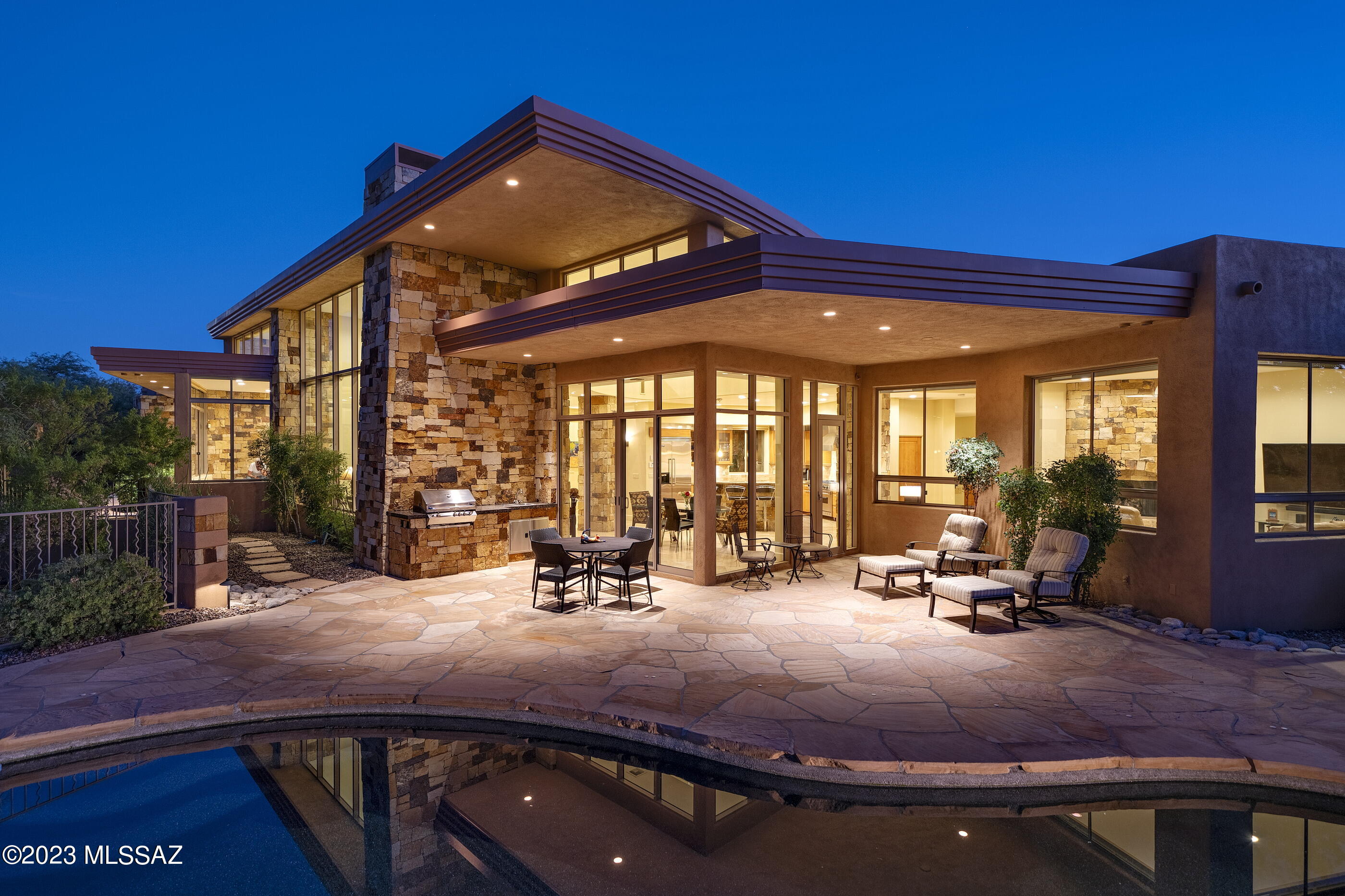 Beautifully designed contemporary home featuring walls of windows showcasing expansive stunning mountain views. Open split floor Plan, 3BR plus Den/Study. 24' travertine flooring, stone accents, alder wood doors, high ceilings and an abundance of natural light. Wonderful open gourmet kitchen w/Viking appliances, island bar, gas range and cherry wood cabinetry. Spacious primary suite features picturesque view of the mountain, custom designed walk in closet. Private outdoor resort like backyard with entertainment area featuring pool, spa and built in bbq area and fire pit. Designed by Tucson architect Bill Gansline.