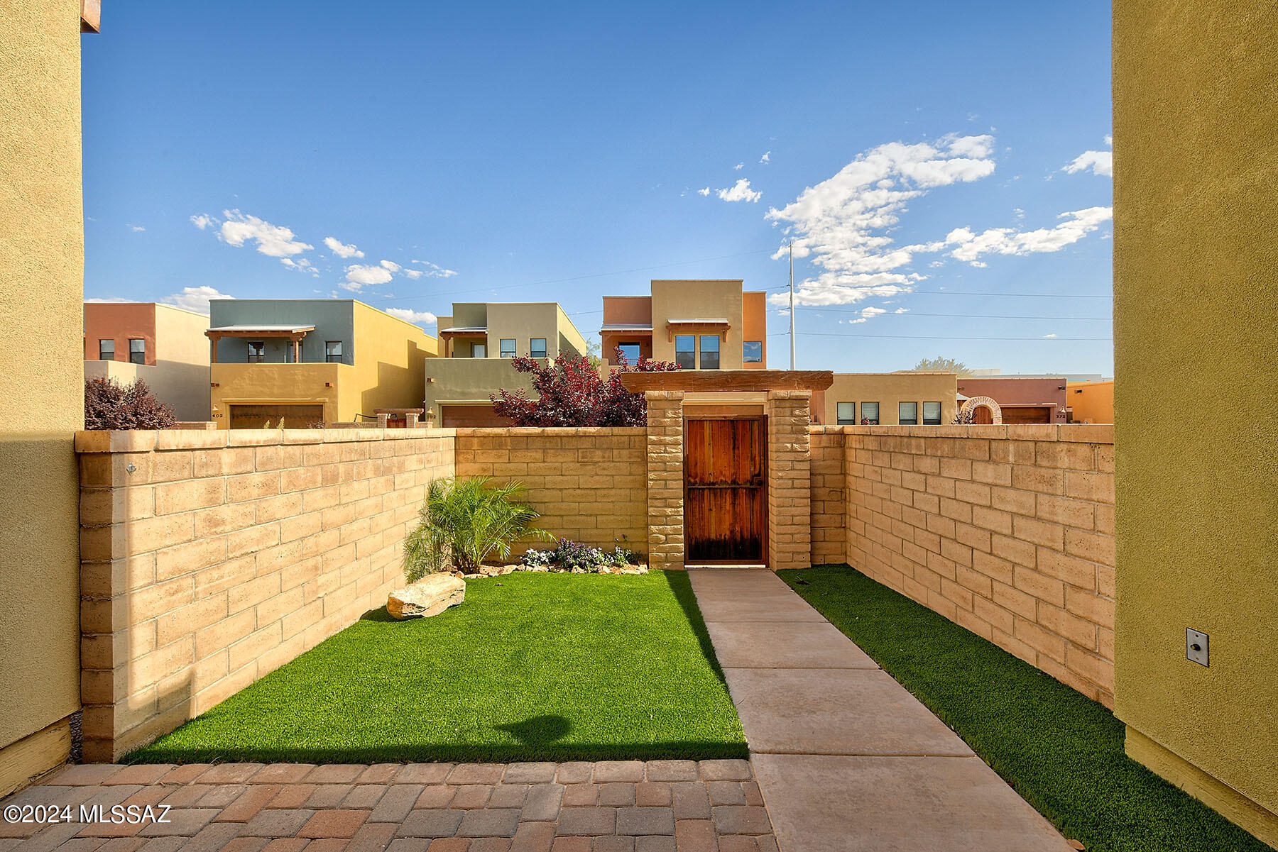 Contemporary southwest style gated community with lovely courtyard entry homes! Fresh Paint!   Move in ready! Welcoming great room concept with kitchen opening to spacious living dining area. Pergo floors throughout!
 Large kitchen island with  stone composite counters and breakfast bar, stainless steel appliances & separate pantry. Upstairs features primary bedroom & ensuite bath with dual vanities plus huge walk-in closet!  Inviting courtyard paver patio & walkway to the backyard with plantings, garden area and peach tree!  The HOA includes, Pool, Spa, Maintenance of common areas including sidewalks, playground area, shaded dog park, streets, parking area. Convenient north/central location with direct Riverwalk/Loop access! A wonderful location to walk/bike ride to the Farmer's Market, Trader Joes or St Philips Plaza! Perfect location surrounded by great shopping and dining!  Straight south on First Ave to the University of Arizona!