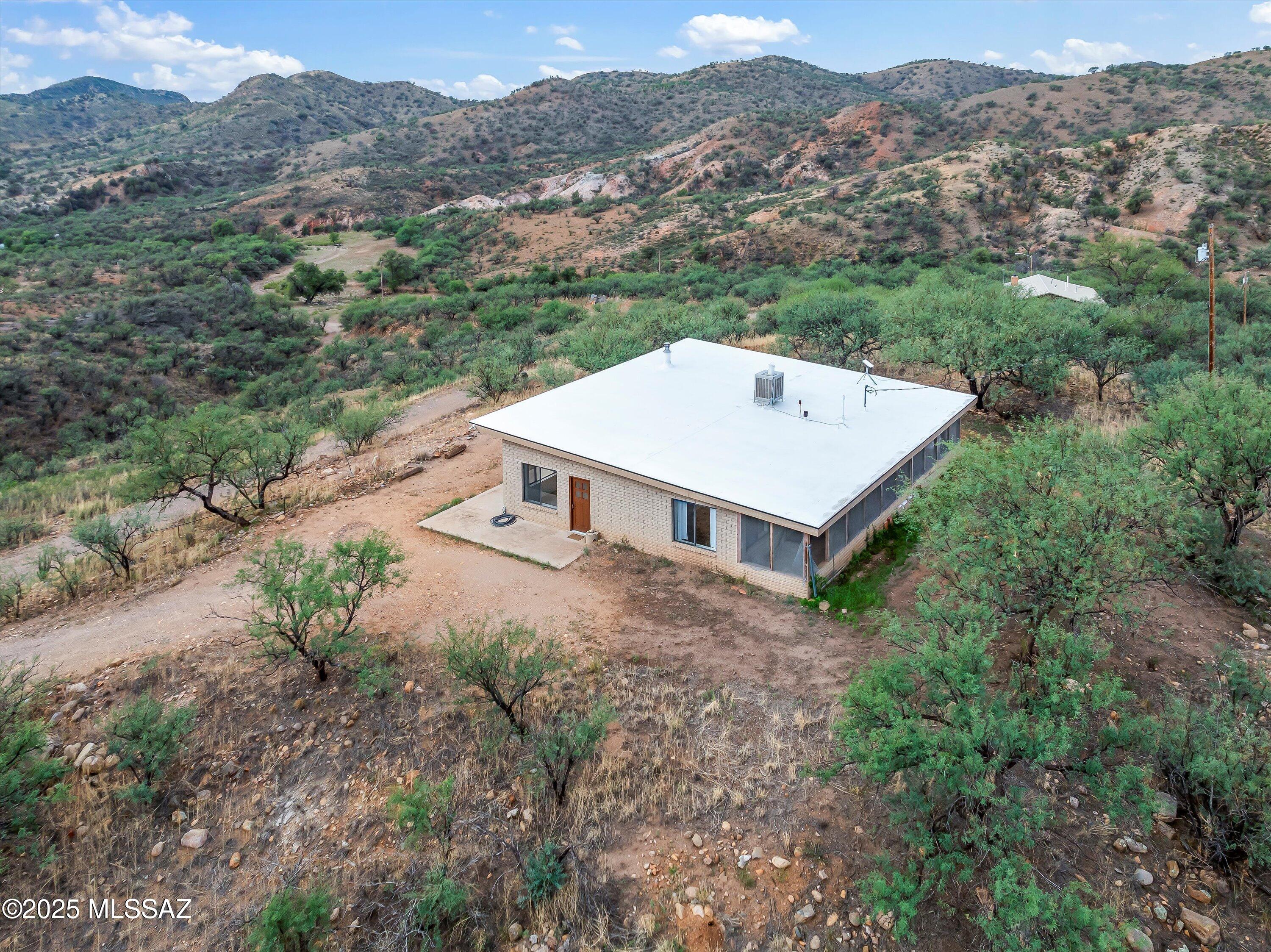 Discover a unique 20-acre Homestead estate in Patagonia, AZ, offering breathtaking Patagonia Mountain views. This property features two homes: a 1765 sq ft main residence with large bay windows framing stunning southward views, and a 1144 sq ft home successfully used as a long-term rental. The expansive 20-acre lot provides privacy and endless possibilities for outdoor activities in the heart of Patagonia's natural beauty. Located in a vibrant community known for arts, birdwatching, and outdoor adventures, this property is an investment in a serene mountain lifestyle, offering a private family compound, rental income potential, or a peaceful escape.