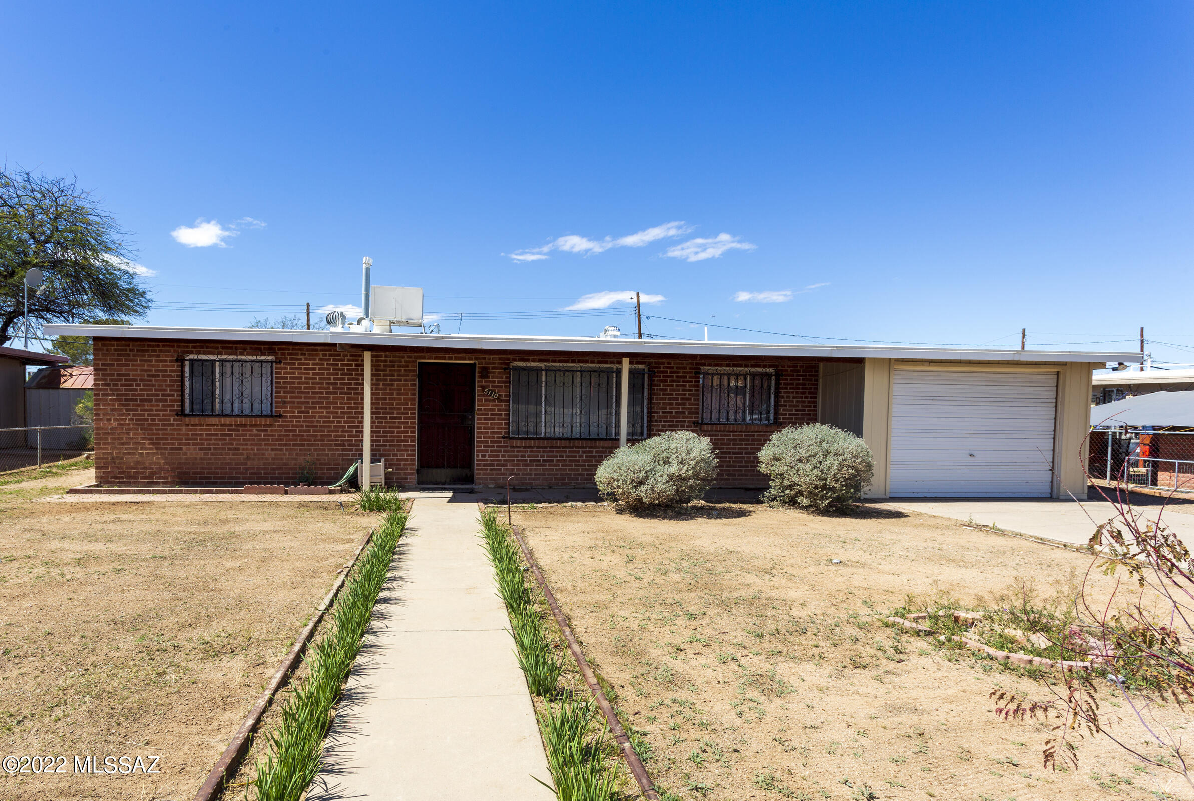 FIRST TIME EVER ON THE MARKET! Don't miss out on this fantastic Original-Retro-Gem! This Move-In ready 1957 home has authentic charm and loads of possibilities. Well-maintained 3 bedrooms, 2 bath, 1,215 sqft brick home on large 0.27 lot is waiting for you! The kitchen features a working original retro gas stove and unique wood built-ins with a pastel color palette of vintage ceramic tile through out the home. Attached 1 car garage with laundry, utility sink and workshop area easily steps into huge covered patio overlooking the oversized back yard for entertaining or gardening. Double gate access to alley and a large storage shed with covered concrete area to work on projects. New Roof in 2019! New Water Heater in 2022! Home in very convenient South location with easy access to I-19 to I-10 airport, major employers, shopping, schools, easy bus line access and much more. Come view this amazing home before it's gone!! Home being sold AS IS.