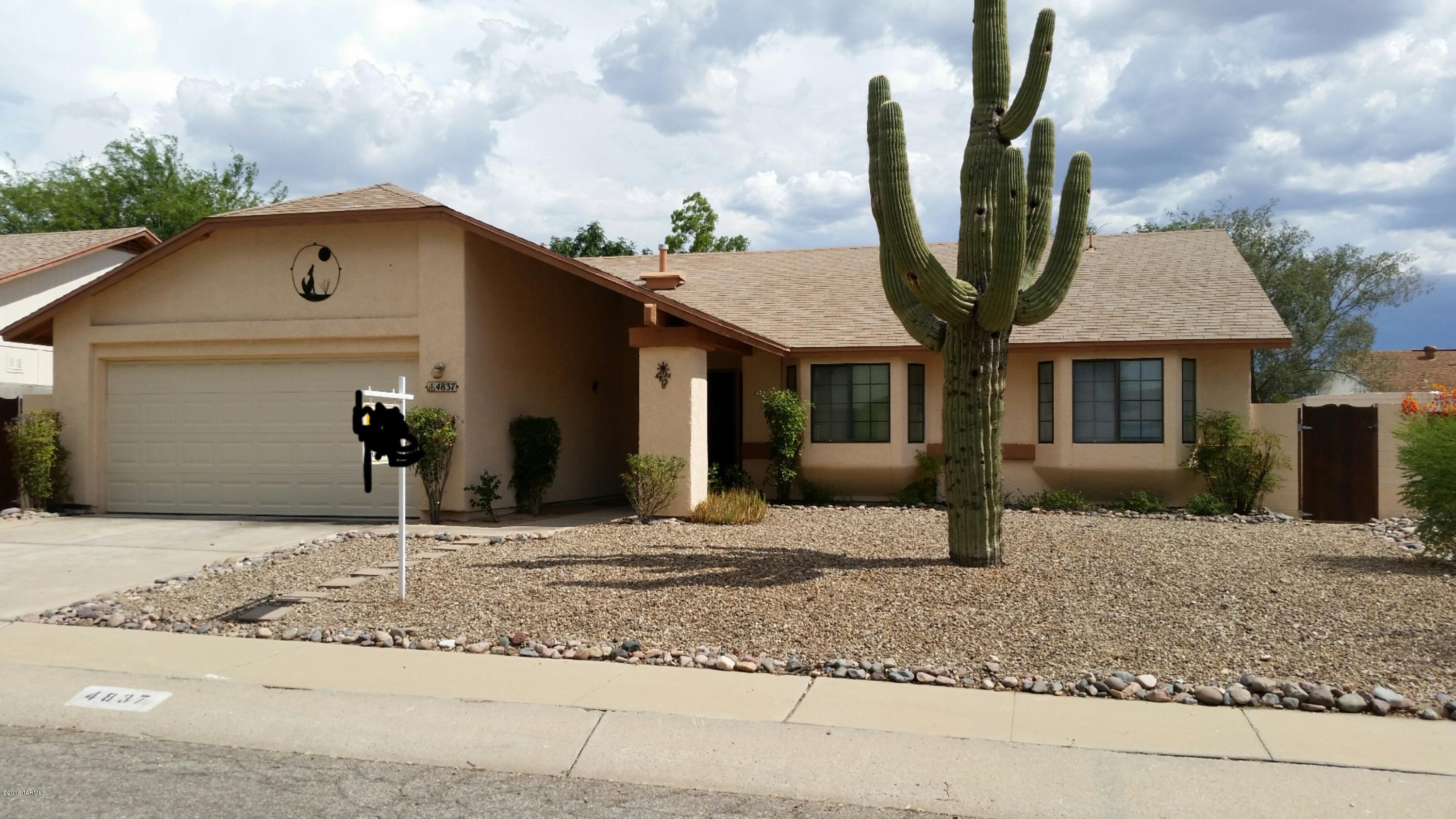 Sought after 3 bedroom 2 bath home with open floorplan and back yard with huge shade trees and block wall. The kitchen is large and roomy, laid out with extra counter space on ''L'' for breakfast bar plus additional cabinets on the side for microwave. From kitchen to dinning area this home flows well into the large living room all with high cathedral ceilings. Then down the hall to the bedrooms, Master suite has the high ceilings plus an interesting layout with vanity separate from the shower and toilet. Large walk in closet.  All bedrooms each have bay window and ceiling fan.  Brand New carpet throughout and A/C unit was serviced for listing running well. 2 car garage has a work shop area with bench. Gorgeous saguaro in the front yard.