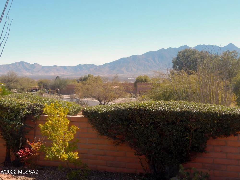 Panoramic mountain views embrace and capture your attention from the moment you enter the living room or walk onto the covered rear patio. Relax in complete privacy on a wrap-around patio surrounded by common area and on a corner lot elevated from the street. The remodeled kitchen, featuring new cabinets and counters, opens to a spacious family room with access to the living room and patio. Skylights and numerous picture windows illuminate the interior of this single family home. The laundry room, part of the master suite, is adjacent to the walk-in closet and has sufficient space for a compact office, looking onto the patio and Santa Rita Mountains.