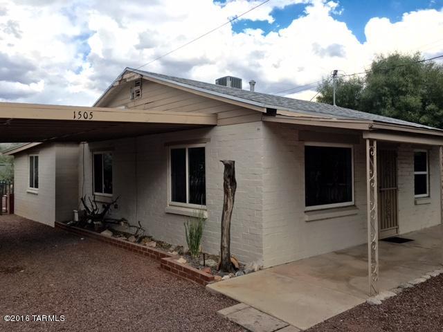 Big bungalow with beamed ceilings. COULD CONVERT DEN TO 2ND BEDROOM!  Super sweet and spacious.  Sizeable lot with your own desert botanical gardens with pathways and storage shed.  Shady front porch and carport.  Very close to Campbell corridor, shopping and dining, easy commute lifestyle.  Bike path to UofA, or Cat Tran stop just 1 block away. Has bonus laundry room/office space off master bedroom  Also a 2nd bedroom/den without a closet, row house layout - through one room to get to the next.  Well maintained move-in ready home with a.c., updated double-pane widows, storage, and great yard! NEW CARPET in Bedrooms.