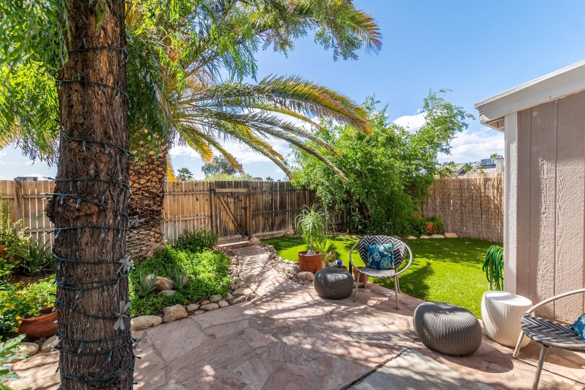 Courtyard entrance welcomes you to this beautiful 3 bedroom home! You are greeted with soaring ceilings, wood flooring, and a custom color scheme. Custom cabinetry with stainless steel appliances and a breakfast bar create this inviting space. Off the stunning master is a sitting area with a sliding glass door leading out to your backyard oasis. Enjoy your outdoor space with plush artificial turf and mature palm trees. This is a darling home, make it yours today!