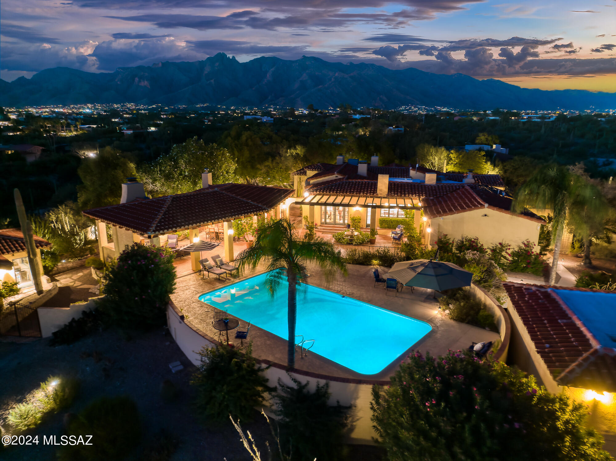 Welcome to ''El Castillo'', an architectural masterpiece designed by the renowned Josias Joesler, nestled in the prestigious Catalina Foothills. This privately gated, hilltop estate blends timeless elegance with modern comfort, offering nearly 5,000 square feet of luxurious living space. The main residence features three bedrooms and two and a half baths, complete with an updated gourmet kitchen and beautifully renovated bathrooms. In addition to the main house, the property includes an attached casita with a private ensuite bath, providing the perfect space for guests. There is also a fully remodeled, detached two-room guesthouse equipped with a kitchenette and full bath, offering visitors the finest in comfort and privacy. A heated and cooled office, exercise room, or (continued) art studio gives you a flexible space for work or leisure. Outside, the estate is surrounded by expansive, manicured gardens with desert landscaping and four tranquil fountains that add to the serene ambiance. Multiple patios are designed for year-round enjoyment, offering breathtaking views of the mountains and city lights. The highlight of the outdoor space is the over 1,100-square-foot ramada, complete with a fireplace, large dining and living areas, and a full outdoor kitchen with multiple cooking stations, including a built-in pizza oven. The resort-style pool has been recently refinished with Pebble-Tec, new tile, and upgraded equipment, including a hybrid electric and gas heater. The estate has undergone many modern updates, including a new septic system, new water lines, and an upgraded electrical service that has been enhanced from 200 to 400 amps. The oversized three-car garage provides ample storage space. Set in a magical and private location, El Castillo offers a rare combination of historic charm, modern amenities, and spectacular views. This luxurious estate is an extraordinary opportunity to experience the best of Tucson living.
