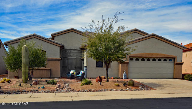 Absolutely stunning home that sits high up the hill overlooking an arroyo and wonderful Mountain views.  Owners have taken pride in this gem and home shows like a model.  Located in Canoa Northwest a 55+ gated golf course community, this home boasts new appliances.  2 bedrooms, large den & a hobby room.  Over sized garage with built-in cabinets.  Enjoy your enclosed Arizona Room, listening to the trickling sounds of the dual waterfalls of the decorative pond.  A real draw for wild birds. Deer & Javelina wonder the nearby hills.  A restful place to come home to.  Truly a must see!