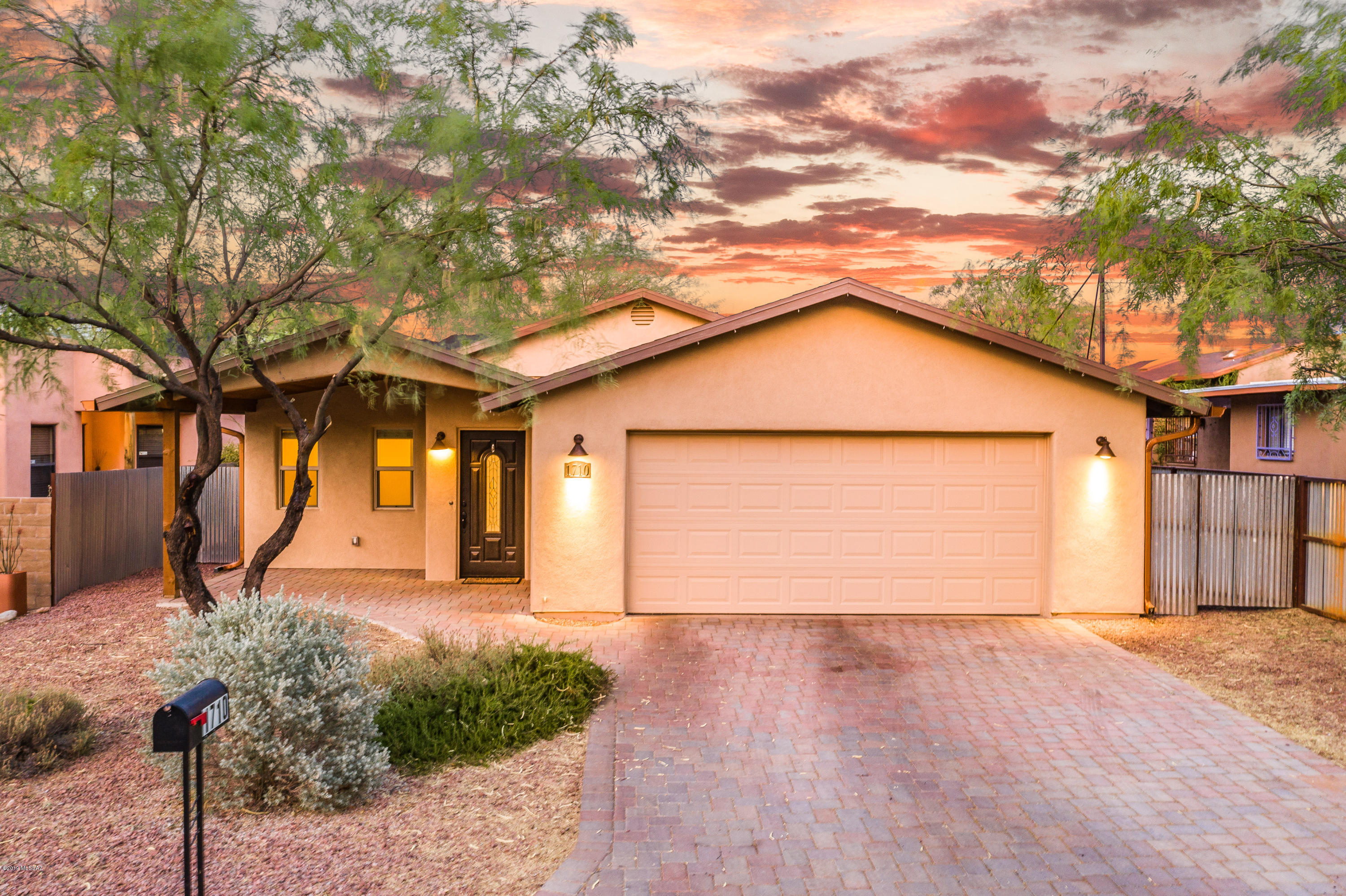 Custom built in 2016, modern 1,925 SqFt 3 bedroom & 2 full bath plus den, move in ready all electric energy efficient home with attached oversized two car finished garage. Located in thriving Central Tucson, only 7 minutes/3 miles to the U of A and 4 minutes/1.4 miles to Banner Medical Center. Featuring: Single story, no stairs, no steps, split floor plan, no HOA, architectural shingle roof, custom pavers driveway and covered front & back patio, soaring cathedral textured ceilings, energy efficient double pane windows w/screens, custom white wood blinds, gorgeous scored neutral color stained concrete floors throughout, skylights, ceiling fans, crisp white wood doors w/black rubbed bronze hardware, internal laundry room w/storage, water line for second fridge and formal dining area.CONTINUE Open concept kitchen with beautiful full slab granite counters, plank wood ceilings, recessed lighting, Nest thermostat (as per seller average electric bill $120 per month set@68 degrees), kitchen bar seating, modern cabinets w/soft close, matching stainless steel appliances (just 3 years old), fridge, built in microwave, dishwasher, stove/oven, garbage disposal, fantastic light from garden window, additional cabinets and full slab granite buffet bar + additional cabinets. Spacious master suite with private master full bath including tiled walk in shower w/bench seating, executive height modern vanity with full slab granite, dual under mount sinks and ginormous walk in closet! Outside buyers will appreciate covered back patio on brick pavers, irrigation, low maintenance private East facing yard w/surrounding metal privacy fencing, gutters, dog run, decorative gravel and mountain views. No CC&R's (Covenants, Conditions, and Restrictions) and RV parking allowed. Enjoy the best of both worlds, Central Tucson location in an updated newer built, move in ready home. Call to make your appointment to view today.
