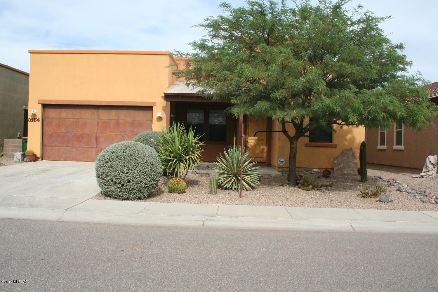 Seller will accept or counter offers between $275,000 & $295,000. Entertainer's delight in The Pines/NW Tucson. Orig builder-so home boasts custom exterior lights/rustic steel garage door.  Interior of split plan home welcomes you w/warm custom paint, immense kitchen w/massive island, customized cabinets & newer appliances opening into bright & spacious great room. Towering ceilings increase sense of spaciousness & are enhanced by custom lighting throughout.  True master suite w/separate sitting room or ?? Roomy master bath w/shower & garden tub and extensive double sink vanity. Finished garage w/tremendous storage/workspace & installed track storage system w/specialized storage.  Open area to east off backyard allows enjoyment of outdoor events in lushly landscaped setting w/two patios.