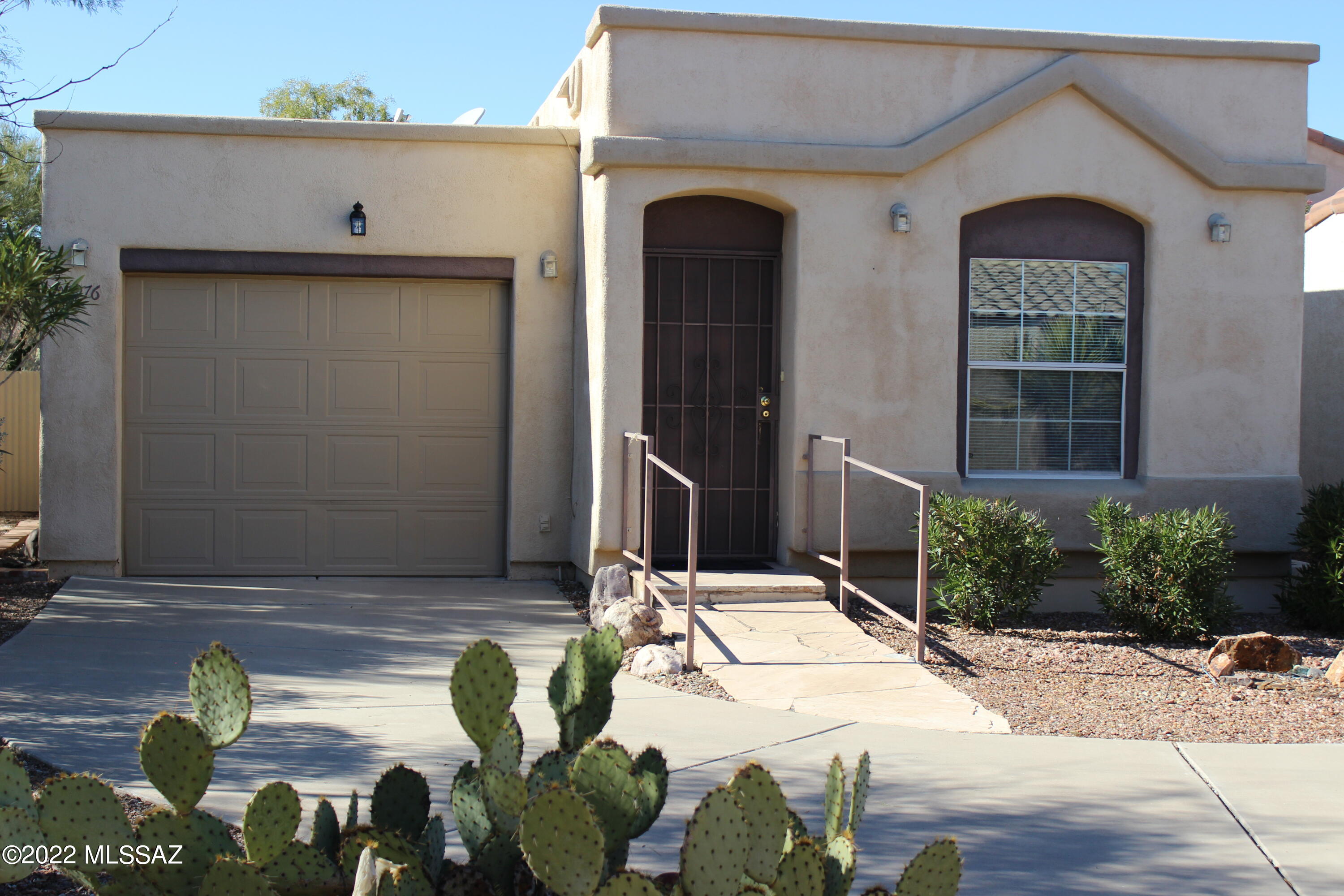 Excellent opportunity to own this premium lot with extended driveway, tucked in desert corner with no neighbor behind.   Enjoy quail & desert surroundings in private partial covered brick patio with view wall or entertain & relax in enclosed AZ Room with wet bar & ceiling fans.  Easy maintenance front yard has gravel, flagstone walkway with rails, storm door & motion censored lighting.  No carpet inside with wood laminate flooring, sky lighting offers plenty of natural light, elevated ceilings, & ceiling fans for extra cooling comfort.  Kitchen has gas stove, stainless French door fridge with icemaker, tile accent countertops, breakfast bar & plenty of storage space throughout.  Full sized stackable front loading washer & dryer included & bonus room used as bedroom/can easily be converted.