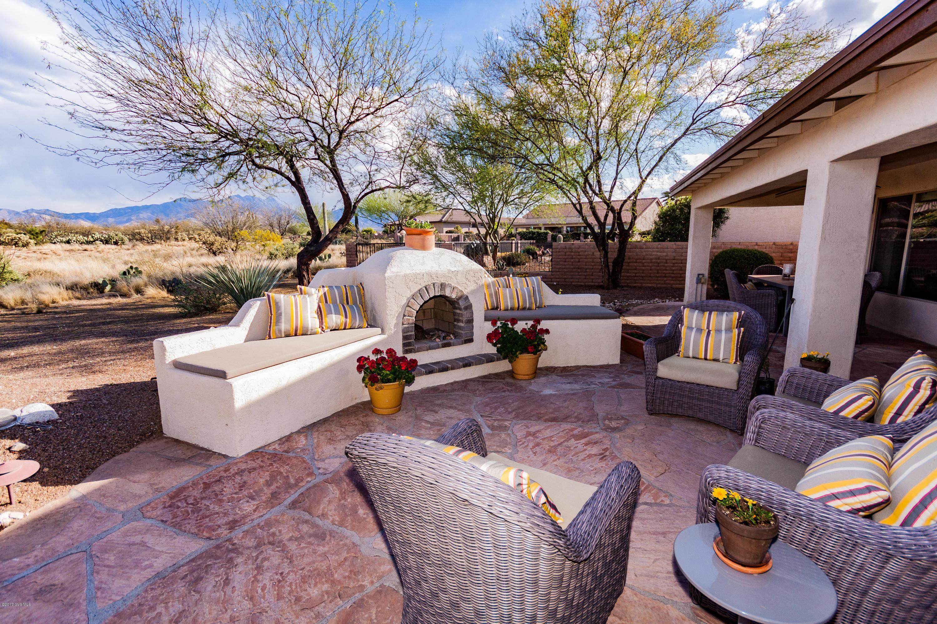 A backdrop of breathtaking, stunning views of the Santa Rita's in a backyard w/ water fall, Kiva fireplace, open space & flagstone. Is quiet, peaceful, private, & beautiful. Extended Laredo is 1900 sq ft of upscale, sophistication. Granite countertops, chic s/s applcs, double center island, rich, cherry cabinets in the ext. kitchen. Two sliders off great room to covered flagstone patio promise double views of the mountains. Track lighting lends a modern illuminated softness to every room. Both bedrms have large bay windows to view that spectacular panorama. Extended. guest room, 2nd bath & den. Stone countertops & showers in both baths. Front shade trees, flagstone path & patio w/fountain. No expense spared when built. Come see this house!Some furnishings incl. others SBOS. A backdrop  of breathtaking, stunning views of the Santa Rita's in a backyard with water fall, Kiva fireplace, open space and flagstone. It's quiet, peaceful, private, and beautiful. Go inside and the experience continues. This extended Laredo is 1900 square feet of upscale, contemporary sophistication. Granite countertops, chic stainless appliances, double center island, rich, cherry cabinets in the extended kitchen. Two sliders off the great room to the paved, covered flagstone patio promise double views of the mountains. Track lighting throughout lends a modern illuminated softness to every room. Both bedrooms have large bay windows to view that spectacular back panorama. The guest room, second bathroom and den all are extended. Both bathrooms have stone countertops and showers. Though