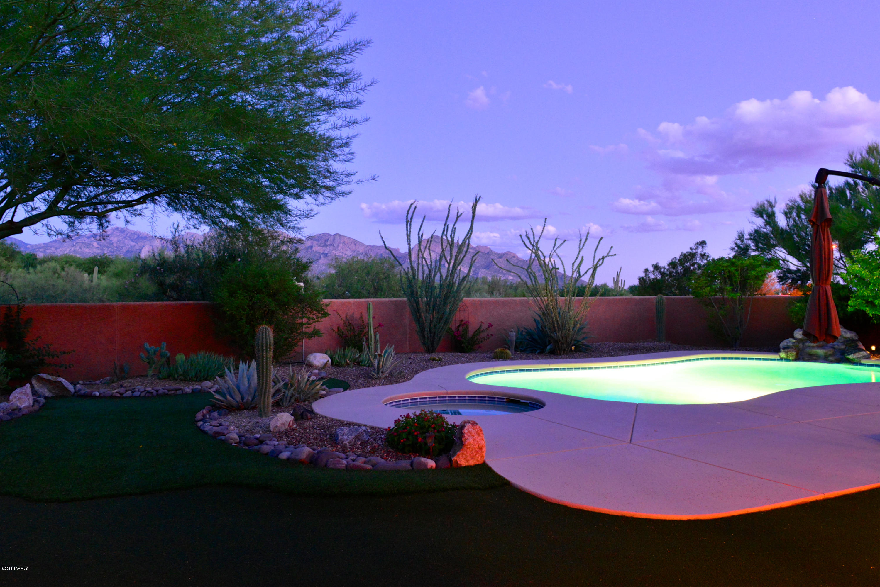 Spectacular sweeping Catalina Mountain/Pusch Ridge views from this immaculate 4 bdrm/3ba, 3002 sq ft. home in the foothills of Oro Valley. Nearly half an acre of pristine landscaping includes a crystal clear salt-water pool with rock waterfall feature, spa, expansive patio with built-in gas barbecue grill, recessed lighting and a manicured putting green. Designer privacy screen doors invite you in to an expansive open-concept living area complete with ceramic tile and walls of windows. Updated and modern kitchen boasts lightly colored Granite countertops, linear mosaic tile backsplash, rich Cherry cabinets and stainless steel appliances including a double oven, dishwasher, built-in microwave and gas cook top. Pool Barrier included in sale! Double doors welcome you into the spacious master suite complete with stunning mountain views and an ensuite sure to help you relax and unwind. Soaking tub with ceramic tile surround, glass shower, chrome fixtures, cherry cabinets, and a walk-in closet with custom built-in cabinetry. Laundry room includes wall to wall cabinets and a deep stainless steel sink. The roomy 3-car garage boasts plenty of storage. Come experience this home for yourself!