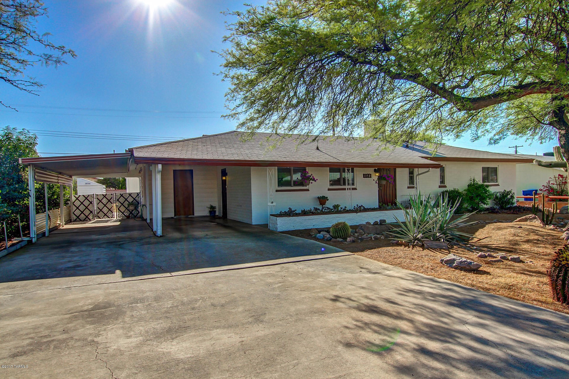 Meticulously Maintained Charming Mid-Century Ranch Style Home with mature shade trees and move-in ready. Updated with High Efficiency HVAC system and many more updates while maintaining the home original appeal. Soothing palette, beautiful wood-looking laminate floors, cozy window seat, ceiling fans, window shades, and spacious floor plan.The eat-in kitchen features beige appliances, stylish counters, and wood cabinets with hardware. Carpet in 2 bedrooms, ample closets, and 2 baths. Enjoy the Arizona Room and backyard with paver patio with plenty of space for a pool!! Large workshop off the 2 car carport provide endless possibilities. Located minutes from restaurants, shops and local attractions. Will NOT disappoint!