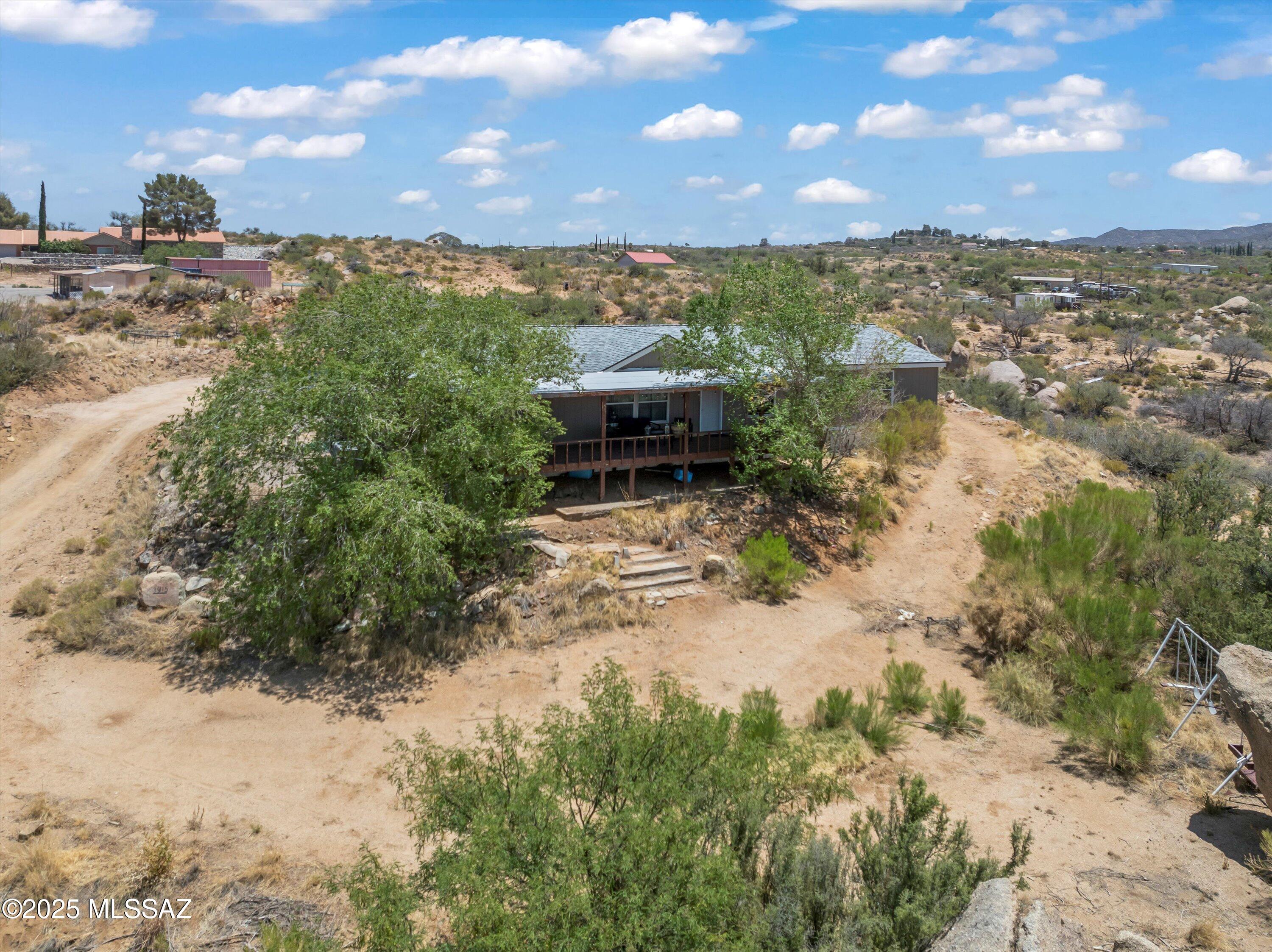 Discover your own piece of Arizona paradise on this stunning 1.25-acre elevated lot in the desirable town of Oracle, just north of Oro Valley! This 4-bedroom, 2-bathroom manufactured home offers tremendous potential for those ready to add their personal touches in one of Southern Arizona's most sought-after locations, where the higher elevation provides a welcome escape from the desert heat.
The generous acreage offers endless possibilities for equestrian activities, workshops, RV parking, or whatever your rural lifestyle demands. No HOA means complete freedom to customize and develop your vision. The elevated lot provides commanding mountain views, spectacular sunsets, and abundant wildlife viewing opportunities throughout the surrounding desert landscape.
The open floor plan features a split-bedroom design for privacy, plus a versatile living room/family room concept perfect for a home office or den. Walk-in closets in bedrooms, dedicated laundry room, and natural gas for efficient heating and cooking - no hassle with propane tanks! Recent roof replacement in 2023 provides peace of mind. The front deck and paver patio provide excellent foundations for outdoor entertaining once you add your personal touches.
This charming foothills community offers small-town living with excellent outdoor recreation, state parks, hiking trails, and easy access to the Coronado National Forest, all while being just 25 minutes from Tucson's amenities. Experience occasional picturesque winter snow (averaging 11 inches annually) while enjoying year-round mild weather perfect for outdoor activities.
This property offers a rare combination of space, location, and potential in Oracle's sought-after market. With over an acre of horse-friendly land, mountain views, and the freedom to customize without HOA restrictions, the possibilities are endless. Don't miss this opportunity to create your own piece of Arizona paradise - schedule your showing today!