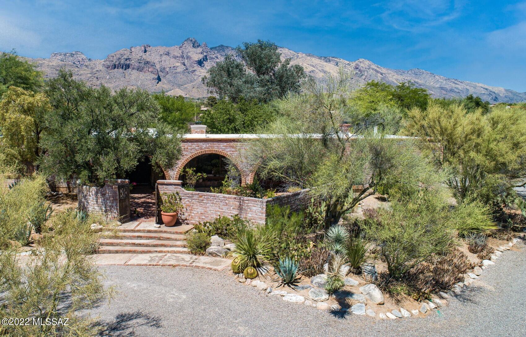 Seller will entertain offers from $875,000 to $925,000. Catalina Foothills Estate offering amazing mountain views, privacy and lush oasis backyard with pool and outdoor fireplaces. One of the last Murphy built homes, completely custom with many built-ins and ample storage. Very well maintained and preserved. Kitchen features a pass through opening to sunroom. Two of the large ensuite bedrooms are located on opposite sides of the home, one has a large walk-in closet and both feature beehive fireplaces. Truly one of a kind home to be treasured.