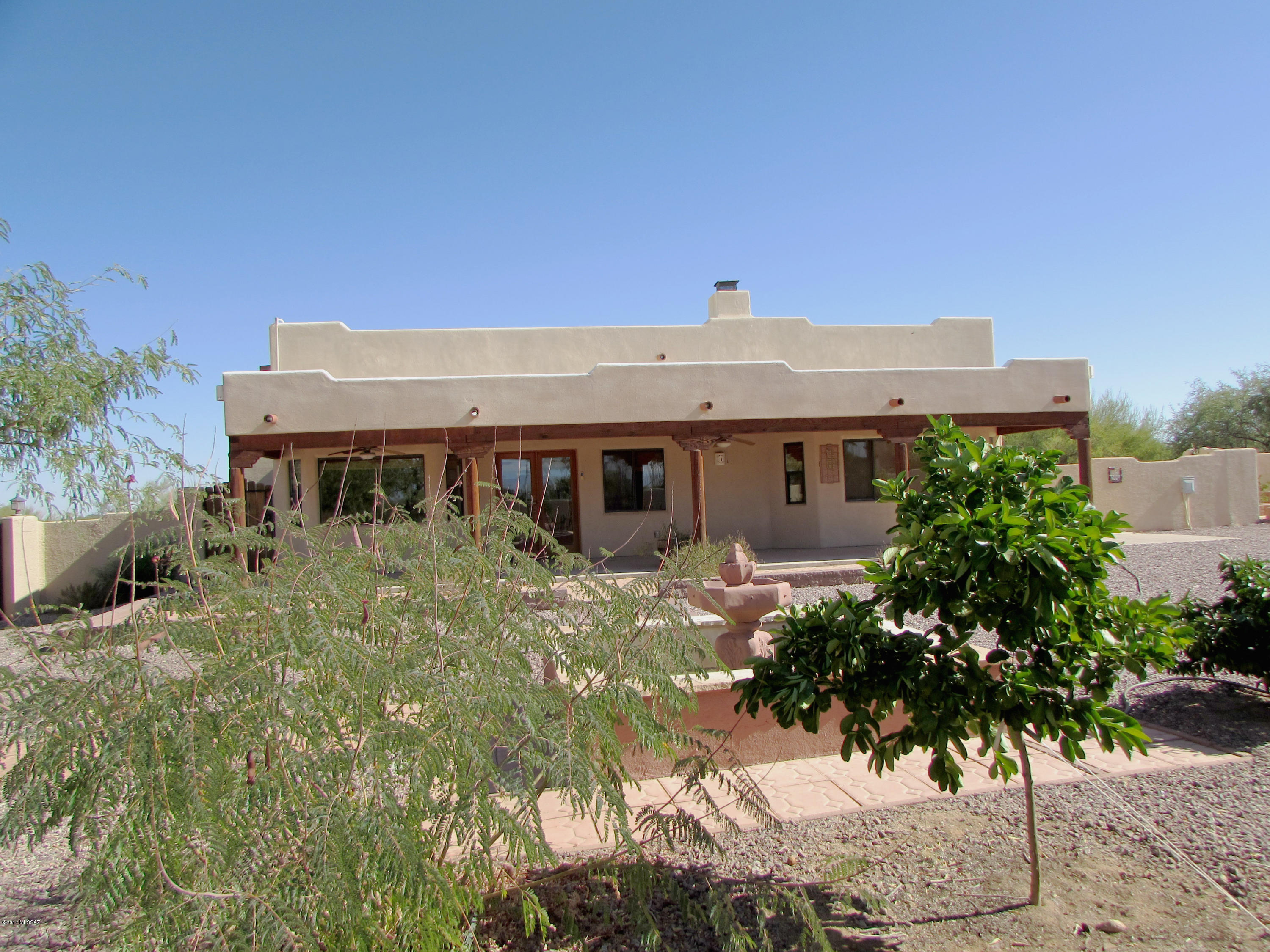 The home is located in the beautiful Sonoran Desert on a corner lot and it is just the perfect setting for this special home. Welcome into the Great Room that features wood plank and vega beamed ceilings & recessed lighting. Maple cabinets, an Appliance Garage plus a large island with breakfast bar in the kitchen. Large dining bay nook overlooks the wonderful rear enclosed yard. A beautiful corner beehive fireplace for those cool desert evenings. Built-in bookcase for your library or displays.  Master bedroom suite also has wood plank and vega beamed ceilings plus lovely tile accented bathroom & walk-in shower.
Interior doors are all natural wood. Several niches throughout the home, some lighted. Full length covered patio - so attractive! Also uncovered  patio areas, fountain, raised garden / planting area & citrus tree area. Large storage / workshop with electric compliments the rear yard. Double access gates in addition to single gates to access the rear yard. Sellers will provide a $2000 carpet allowance to buyers at the Close of Escrow.