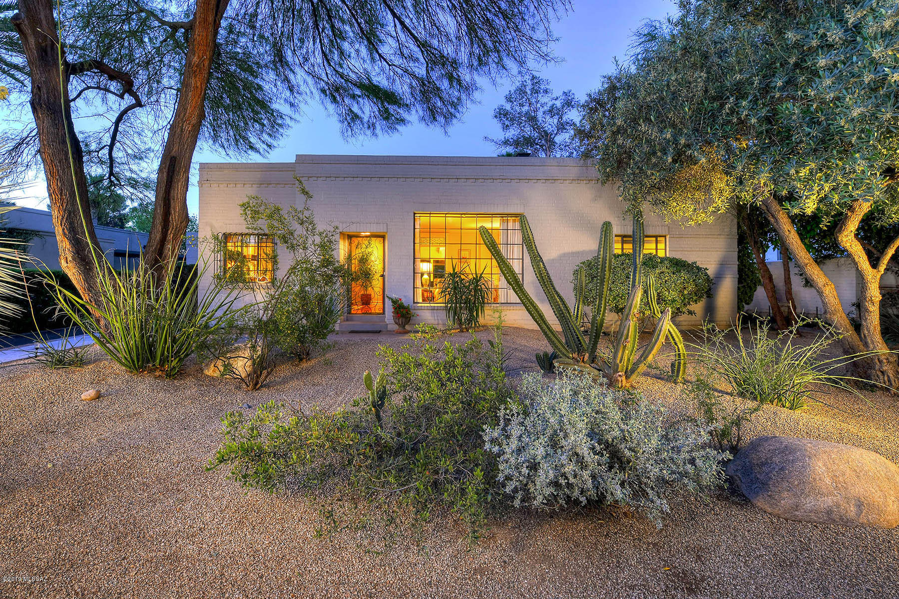 Classically charming  1934 Territorial home with guest quarters, in a lovely location near the Arizona Inn.  Grand living room/dining room with floor to ceiling French casement window & fireplace.  Hardwood floors & original Mexican concrete tile.  Family room has FP, wall of glass overlooking a beautiful covered patio and garden. Vintage kitchen has butler's pantry and eat in area. Master has en-suite bathroom, 2nd bedroom has built in bookcase & sitting room.  2nd bathroom includes a laundry room/storage. Lush backyard has mature landscape, gardens, fountain.  Separate guest quarters includes a kitchenette, colored concrete floors, living space and full bathroom. Extra storage room/workshop. 2 car garage-port. Walking distance to the U of A, Banner Hospital, Arizona Inn & the Modern Street Car.