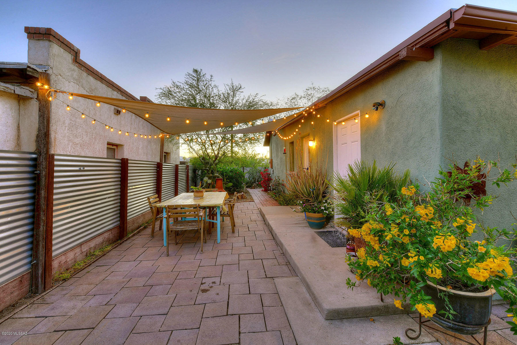 Truly charming Blue Moon Barrio area home awaits! Private, walled and fenced yard offers entertaining opportunities, with plenty of room for storage, bicycles or pool on a nearly 8,000sqft lot. You'll enjoy lovely plank and beam covered patio decorated with gorgeous octagonal saltillo tile. Inside, the home is awash in bright open light & lovely Mt. Lemmon Pine floors, newer kitchen appliances, cabinets and granite counter tops. Manicured Rear yard features lovely pavers & bright desert plantings, mature fruit baring trees and enclosed vegetable garden. Enjoy the privacy of the fully fenced and enclosed yard...truly a compound! Super cute and will not last long! **Rock Climbing wall does not convey**