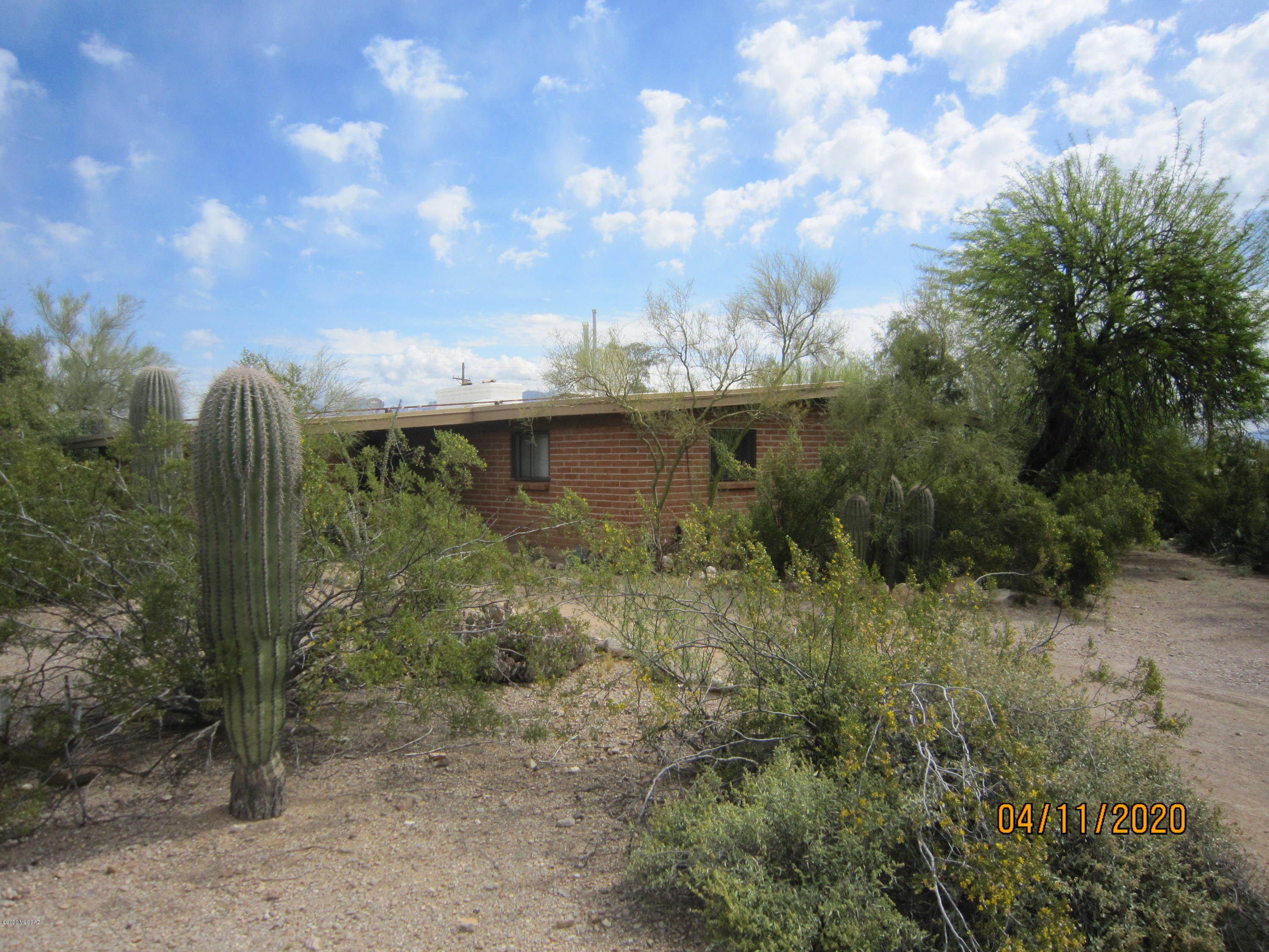 Very Private Adobe Home on over 1/2 Acre Lot with Giant Saguaros and Blooming Palo Verde Trees, Mountain and Sunset Views! 3 Bedrooms, 2 Baths, Beamed Ceilings and Large Covered Patio, 2 Fireplaces, 2 Covered Parking Spaces, Central A/C and Gas Heat. EZ Access to Downtown and I-10. No Fenced Yard for dogs, Abundant Wildlife.