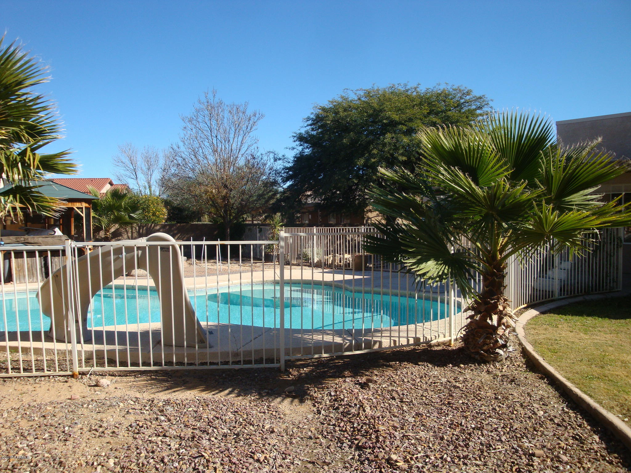 This single level Home is charming and one of a kind floor plan on one of the largest lots in Rita Ranch. Beautiful fireplace in Den, dining areas, Arches, Open kitchen (added 6 foot) with Granite countertops, two covered porches, separate dog run, solar heating for the sparkling pool, extended cool-decking, dual zoned A/C ( new in 2014), a new 15 year roof (installed in 2012), Ceiling fans, 3 solar tube lights, landscaped backyard with numerous Citrus trees. New carpeting in Dining and Family Room. New plumbing,( polybutylene replaced) Lots of room to roam. Come and see.