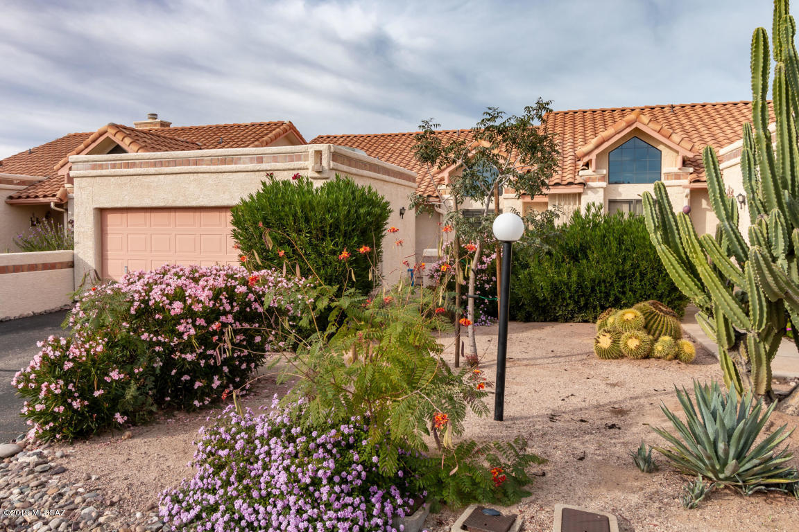 This beautiful Oro Valley 2 bedroom townhome has an open floor plan with large eat in kitchen,  ceramic tile in great room and kitchen, carpet in bedrooms, vaulted ceilings, wood burning fireplace and 2 car attached garage. Community pool and quiet living included.