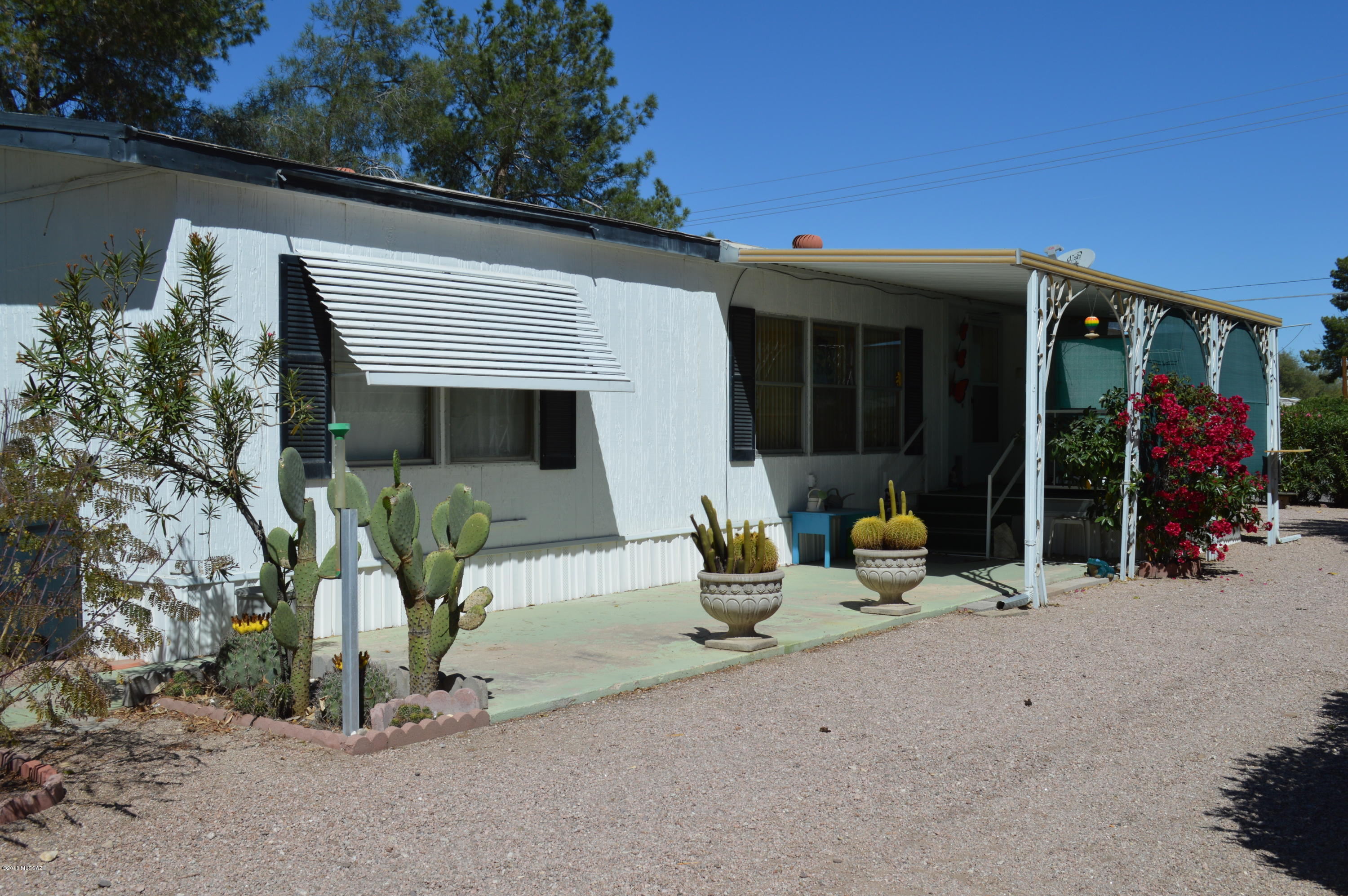 Well Maintained 3 bedroom, 2 bath split floor plan affixed mobile home.  Owner has taken great pride in up-keeping this home as can be observed throughout. Guest bathroom was completely remodeled in February 2018.  Corner lot features mature shrubs for privacy and a low maintenance yard.  Electric gate for ease of entry, large extra height carport fits two cars or a travel trailer.  Bonus feature includes a detached efficiency apartment/guest house that can be rented out for extra income.  It has its own kitchen and bath, hook ups for washer and dryer and an enclosed garage.  Apartment was completed within the last two years.  This is definitely a must see.  Appliances in apartment do not convey.