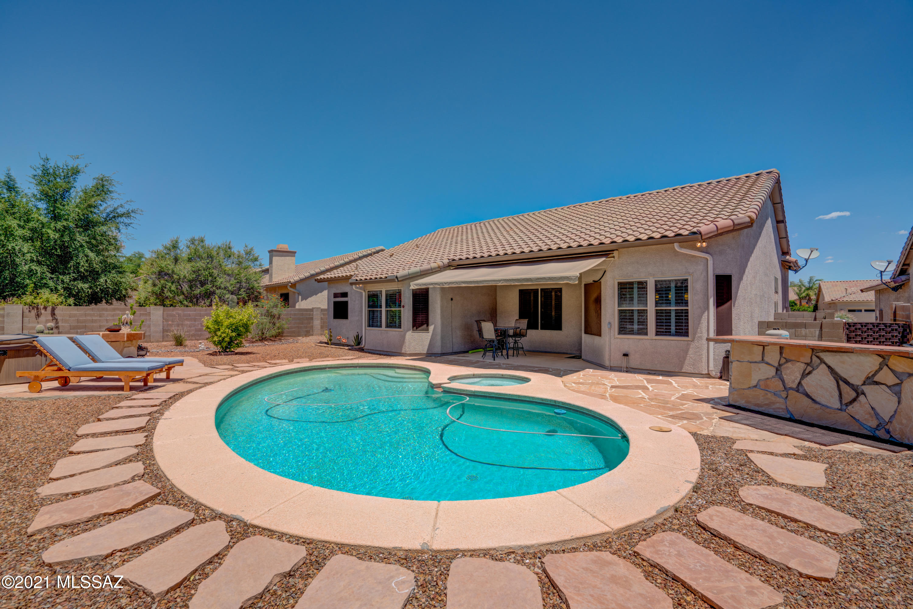 You'll love all the extras in this home from the plantation shutters, scored concrete floor, stone and travertine counter tops, stainless appliances, 4th bedroom with French doors, perfect for your home office, designer interior paint colors, built in sound system, huge master shower, and that is just inside!  Step outside and a large backyard boasts a sparkling pool with spa, separate hot tub and cover, solar blanket for pool, Sedona natural gas BBQ grill on prep/entertaining table, firepit and cement conversation table.  Relax, gaze at the Santa Catalina Mountains and enjoy what Tucson living is all about!  Furniture package available with separate Bill of Sale.