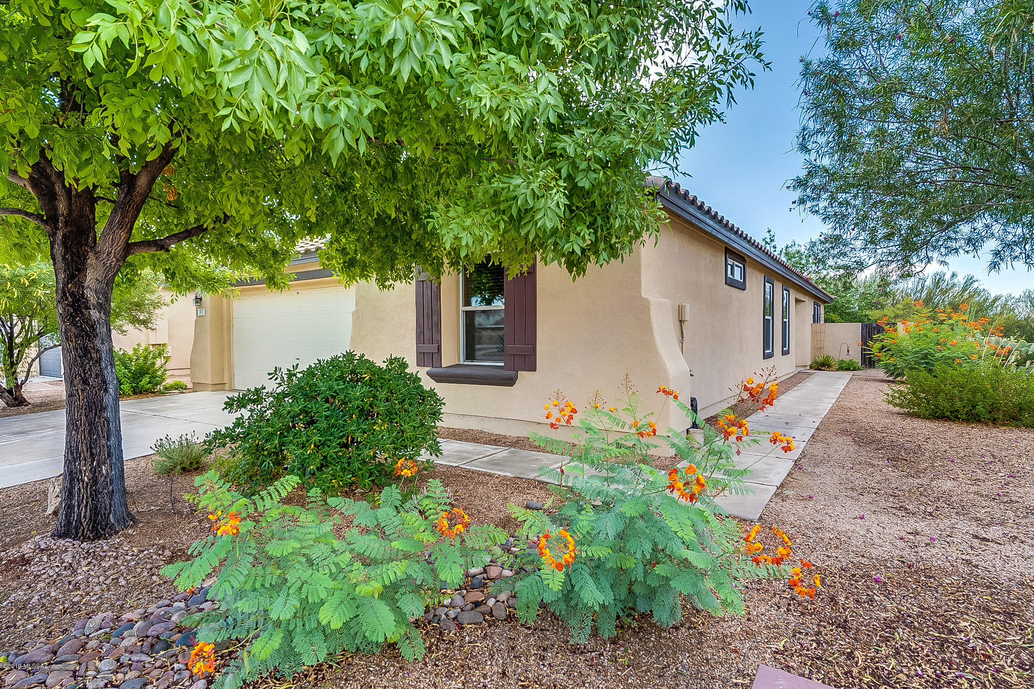 BEAUTIFULLY appointed home and GORGEOUS park like backyard!!! NO REAR neighbors OR side neighbors on one side.
All ceramic tile/wood flooring throughout, open kitchen/great room floor plan, cherry cabinets with roll outs, kitchen island with Mexican tile accents, black kitchen appliances,  French doors off dining area to backyard, ceiling fans and wood blinds through out, den with French doors, decorator paint, covered patio expanded with tile pavers, water softener loop, mature trees,  backyard shed,  built in seating area, built in flower beds and wrought iron see through fencing that opens to natural desert. TRULY a GEM!!!