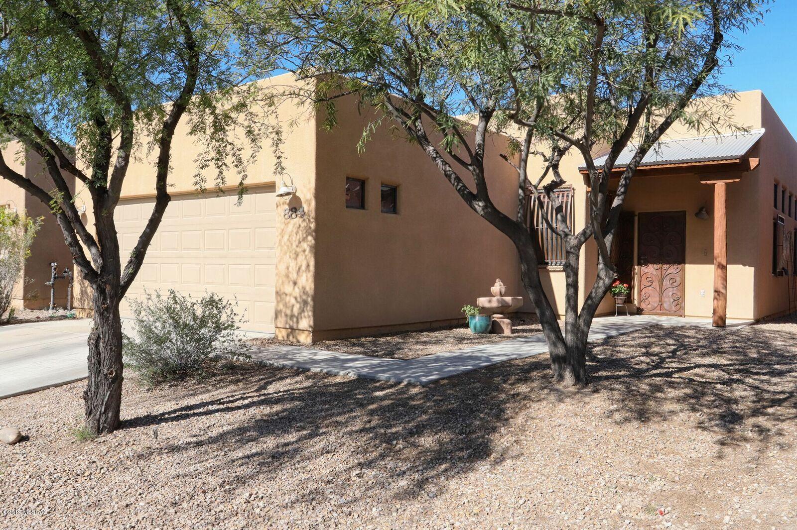 BACK ON MARKET due to buyer financing. This gated neighborhood is just minutes from I-10, downtown, the airport & U of A. Open concept home & cathedral ceilings makes this a great place to gather. The split bedroom plan adds privacy. The master suite has dual closets & sinks with new carpet in the bedroom.  You'll find rustic custom security doors & windows with neutral tile thru out the living areas. Sliders lead out to the covered patio to enjoy the Arizona sunsets, & a great view of A Mountain fireworks. Don't miss the neighborhood park!