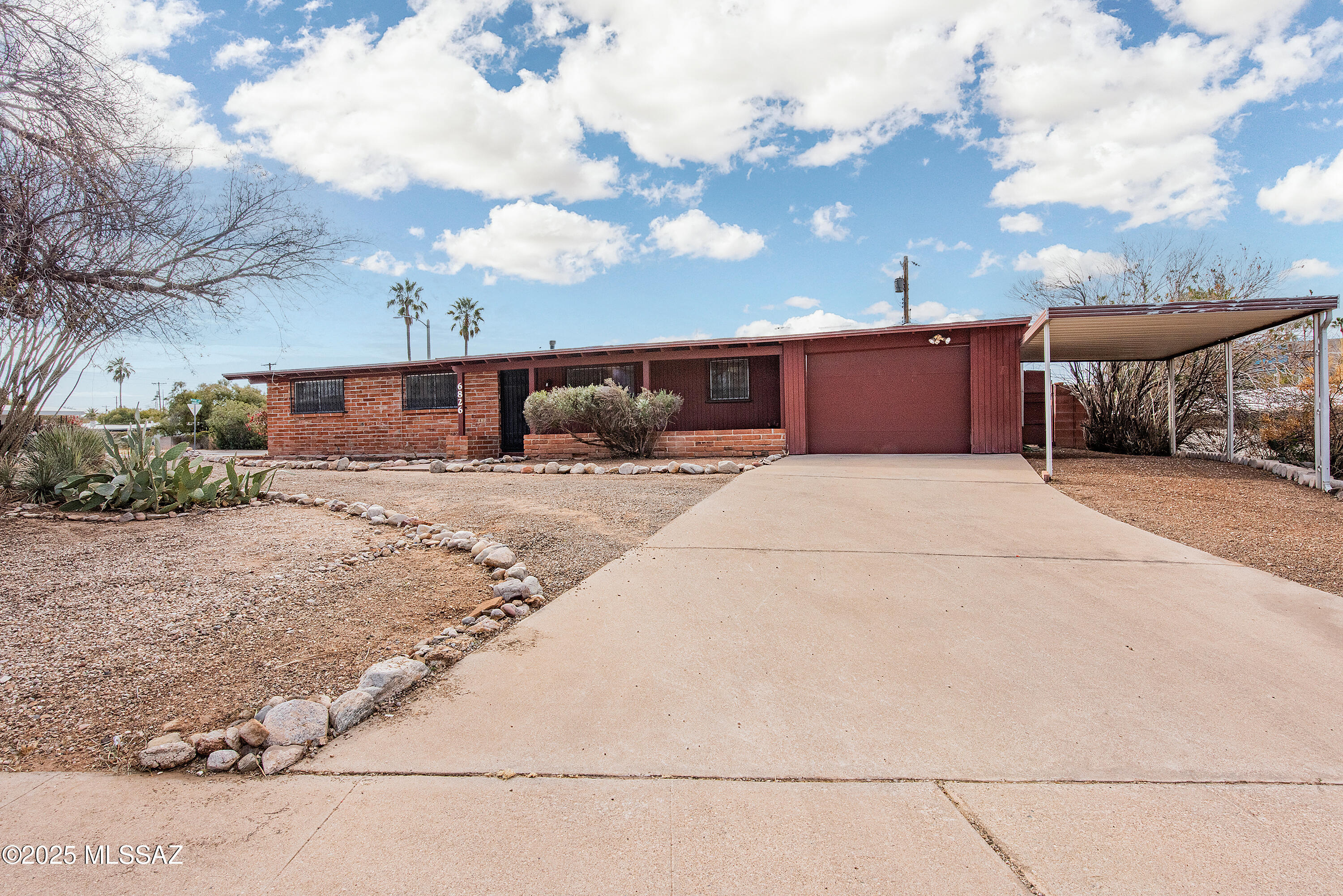 Discover the charm of this burnt adobe ranch-style home, ideally located near Broadway and Wilmot. Situated on a spacious corner lot, this home offers 3 bedrooms, 2 bathrooms, a one-car garage, and a one-car carport. The inviting living room spans 24' x 14', complemented by a dining room measuring 9' x 14'. Inside, you'll find unique exposed adobe interior walls and brand-new wood-grain vinyl flooring that was just installed in 2025. The home also features a generously sized laundry room with a wash sink and a newer HVAC system. Step outside to enjoy the oversized backyard enclosed by a block wall and complete with a storage shed. Best of all, there's no HOA! Conveniently located near shopping, dining, entertainment, and transportation, this home is a must-see.
