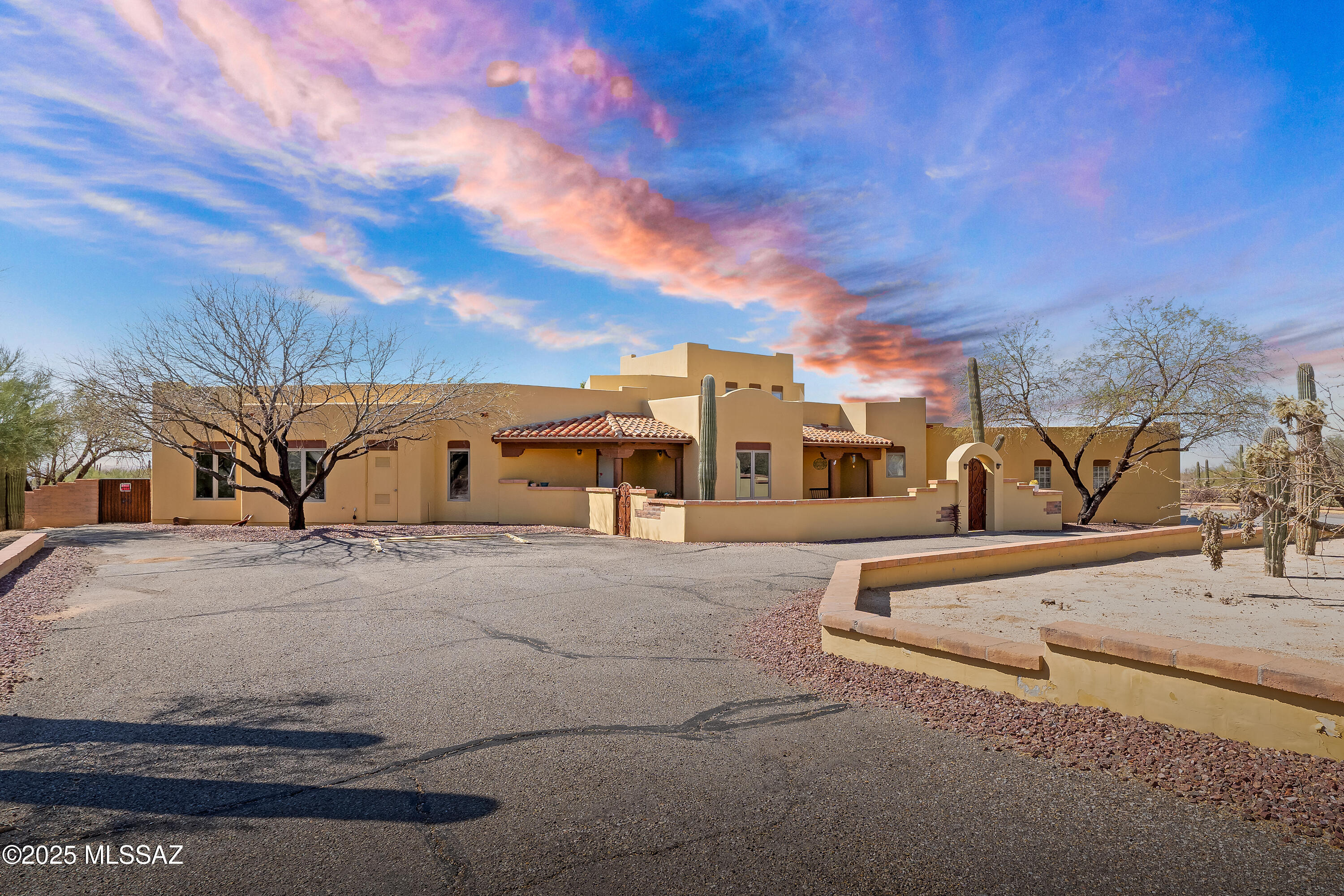 Discover the best of Western living with this exceptional 3.3-acre, fully fenced property. A spacious circular driveway leads to a gated courtyard entrance, and a separate driveway provides access to the equestrian facilities, including an arena, round pen, and four horse stalls. This stunning 5-bedroom, 3.5-bathroom Santa Fe custom home features tile flooring throughout and a high, beamed ceiling in the living room. The large formal dining room and open kitchen/family room create an ideal space for entertaining. Solid wood doors and tile floors add elegance throughout. The living room, family room, and master bedroom all open onto an expansive rear patio and large yard, perfect for outdoor enjoyment and family fun. The inviting pool and spa with mountain view this home has it all.
