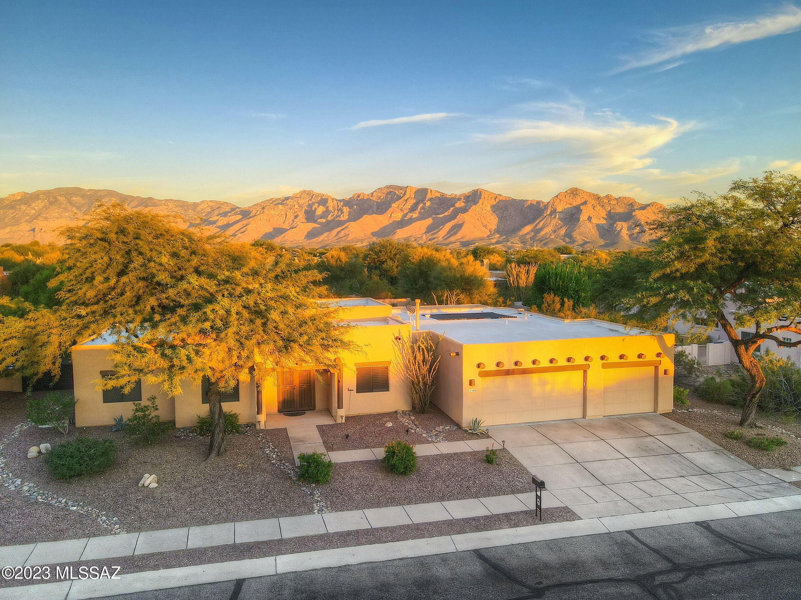 The prestigious Ironwood Canyon is a gated community located in Oro Valley, Arizona that boasts Southwest-style semi-custom homes. This beautiful Santa Fe style home offers a spacious living area, complete with 3 bedrooms, 3 bathrooms & a den/office. It also features window walls and solar tubes to enhance its natural light and bright atmosphere. Upon entering the home, you will be greeted by a classic double door entry into the great room with formal dining. The large great room includes plenty of windows, a cozy gas fireplace & a stunning open kitchen with white two-tone cafe appliances, granite countertops & a modern patterned backsplash. The owner's suite provides a private retreat with French doors leading to the rear patio, a separate split system AC, and ensuite bath with walk-in shower, dual vanity and soaking tub. The backyard is a resort-style oasis featuring a palapa, spa, kidney-shaped pool, raised patios, and a private walled yard with mature fruit trees and breathtaking views of Pusch Ridge. This home is truly a private retreat to be enjoyed.