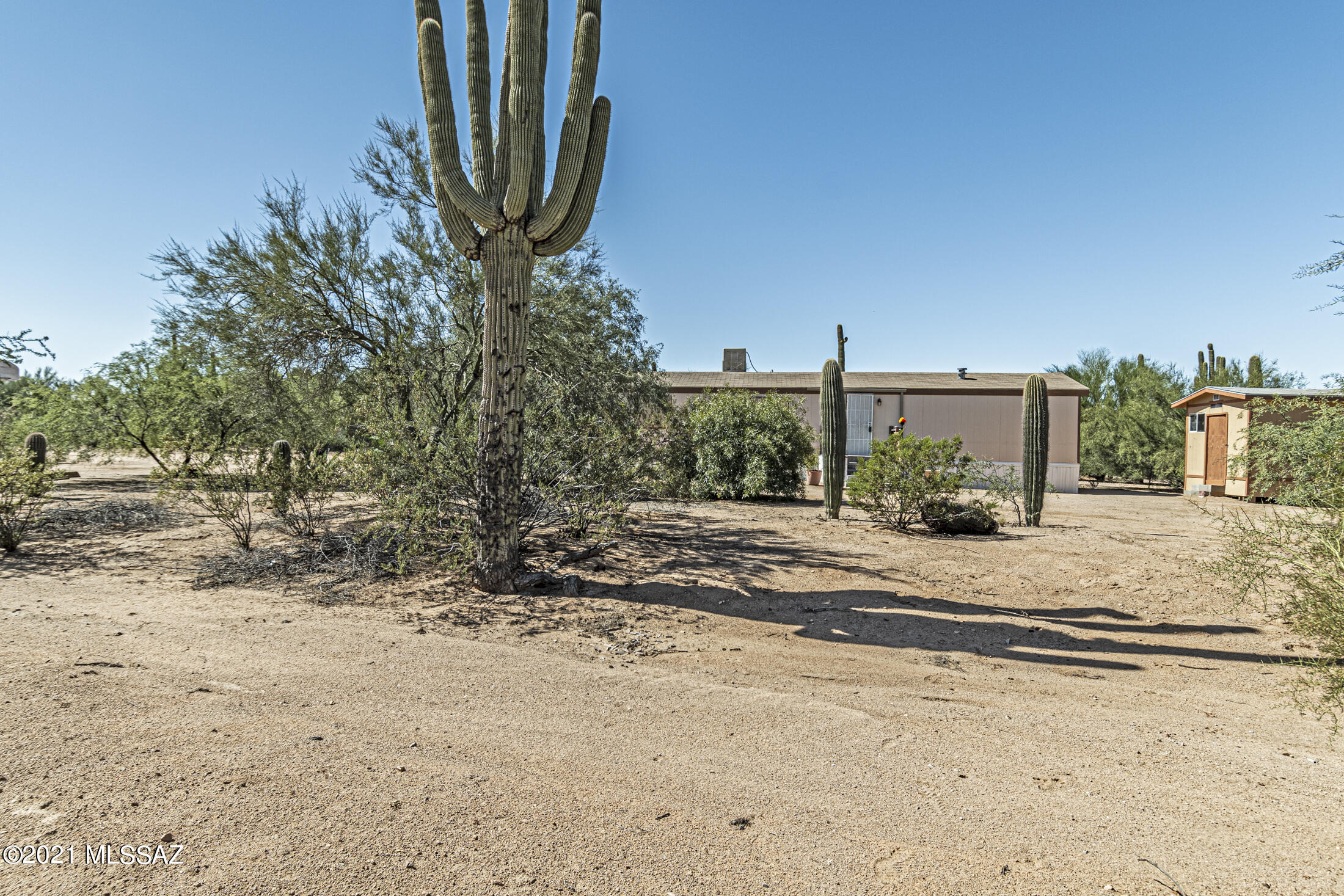 BEAUTIFUL DESERT OASIS W/SAGUAROS & GORGEOUS MOUNTAIN VIEWS!  3BDR/2BA home features a split bedrm plan, lg master suite w/walk in closet, mstr bath has garden tub & separate shower, two other generous bedrms, lg open family rm & eat in kitchen w/lots of cabinets & a pantry, stone flor covered screened patios w/a huge attached workshop/storage.  The acre lot is fully fenced & features covered garden area, fire pit, separate storage shed, beautiful desert vegetation w/majestic saguaros.  Backyard is perfect for entertaining on the barbee.  Horses are OK & lots of room for your RV & all of your other toys and NO HOA!  PRIVACY, LAND & BEAUTIFUL, RELAXING MOUNTAIN VIEWS-RURAL LIVING AT IT'S BEST AT A FANTASTIC PRICE!