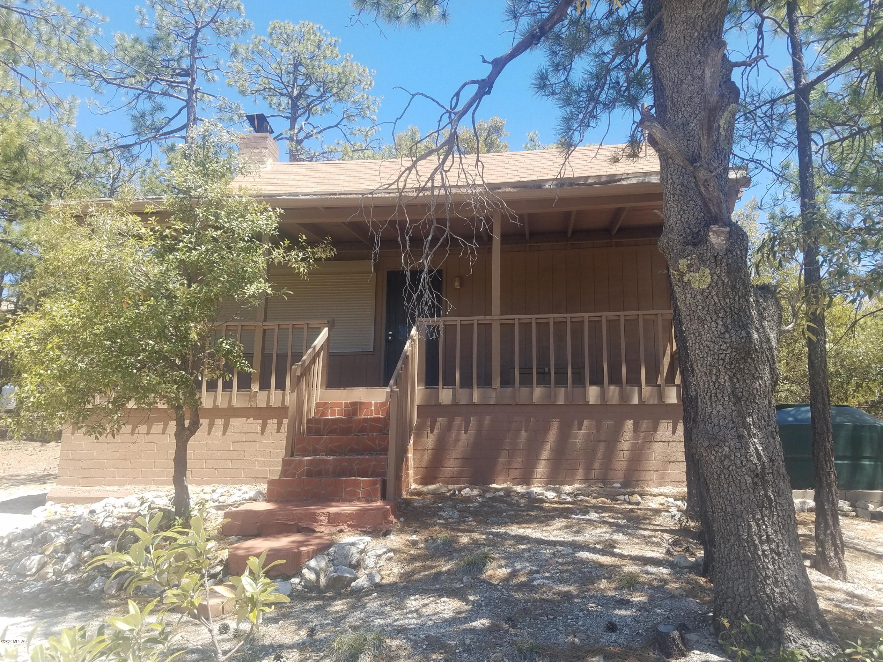 Great get away from Tucson up the mountain road at 7000 ft elevation.  Located in the tall pines, 45 minutes from Tucson.  Large windows allow amazing panoramic mountain and city views.  Beautiful secluded mountain retreat with covered deck. Large stone fireplace in living room.  Beautiful hardwood floors.  Very efficient kitchen.  Kitchen window with view of Lizard Rock.  Large sleeping loft.  Bathroom with composting toilet.  Red brick patio in back yard.  Ready to move in.  Everything stays including furniture, dishes, pots and pans, linens, etc.  This is a Forest Service area where you buy the improvements and lease the land from the US Forest Service.  Call agent for any questions about the cabin or about Forest Service lease information.