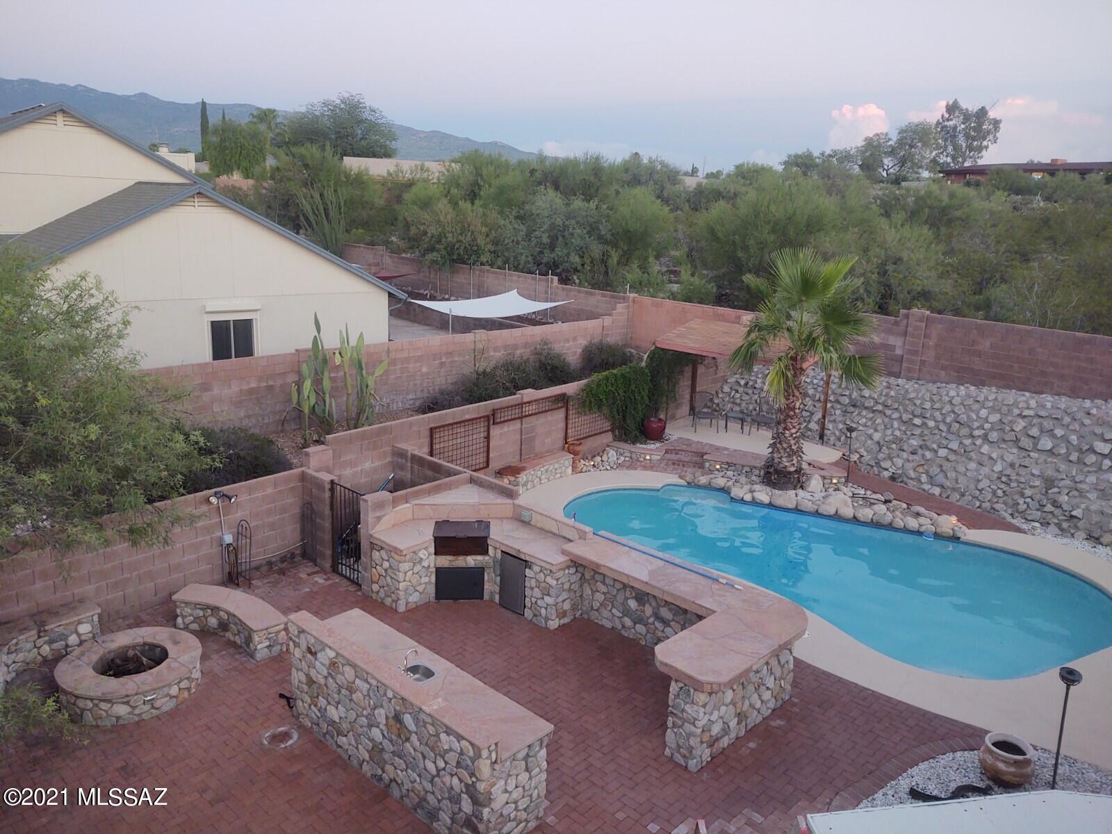GORGEOUS Eastside 3/2 + DEN home on a DOUBLE SIZED LOT w/ .26 acres!  NO POLY PIPES!  Enjoy the best of Tucson outdoor living in this amazing backyard w/ POOL, outdoor kitchen, fire pit, ramada, lighting, custom iron double gate & storage shed!  Charcoal grill, sink,  mini fridge & flagstone countertops!  
 Stunning interior features vaulted ceilings, ceramic tile, ceiling fans, custom touches in  kitchen w/ faux brick accents, granite countertops, recessed & pendant lighting, SS appliances & gas range.  NEW carpet in living area!Custom tile work in primary bathroom in shower/vanity. Secondary back yard area has large cov. patio, propane grill/flagstone counters, built-in seating & new decorative rock!  Exterior of home, pool deck &  pool fence repainted 8/21.  Water heater 3/21. LOW HOA! Polybutylene pipes were replaced 7/20.  

Water heater replaced 3/21.

Dishwasher replaced 2/20,

Garage door replaced 2016.

Washer/dryer and refrigerator convey as-is.