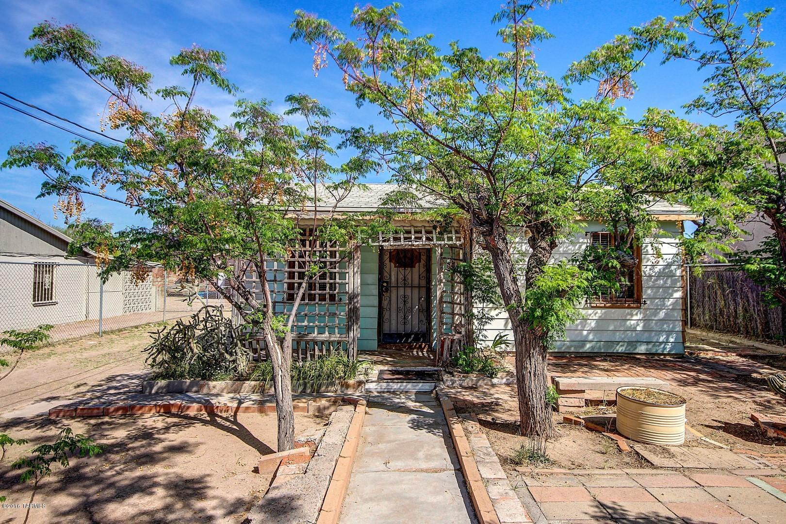Cozy 1956 Move-In Ready 2 bed, 1 Full Bath Home ready for handyperson & TLC in a neighborhood filled with vibrant Southwestern culture & heritage. Home includes good sized living room; eat in kitchen with good counter space & cupboards; good-sized linen closet; lots of windows t-out; inside laundry room; large walk-in storage room off master bedroom; covered front porch & patio area in shade. Situated on a street with a cul-de-sac, nice sidewalk with vintage style Street lighting on a large, fenced-in lot with great soil for gardener! Access to kitchen from attached 2-car covered carport in back of home that has a great work & storage area. Easy access to I-10, I-19, downtown, schools, UofA & PCC. Close to paved city bike path looping around Tucson area. Don't miss this great opportunity!