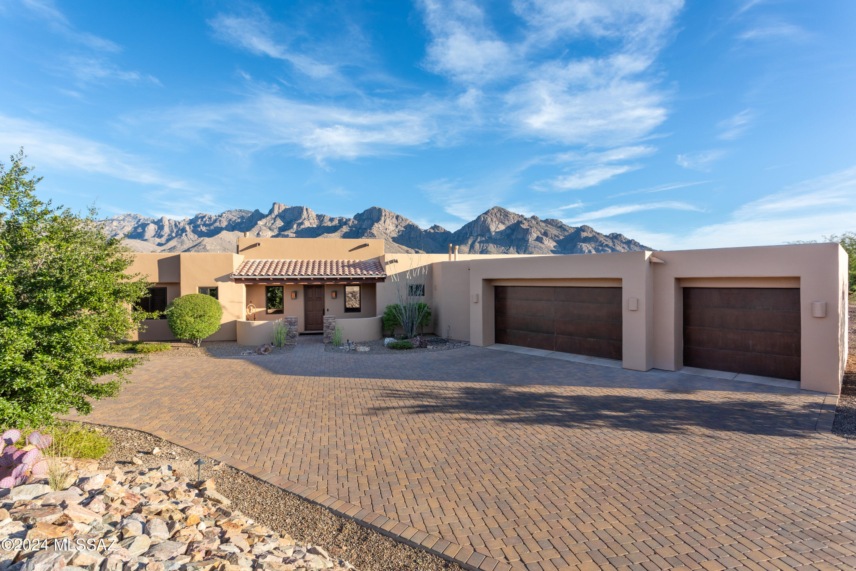 Indulge in panoramic view perfection! Nestled in the prestigious Catalina Ridge neighborhood in the heart of Oro Valley. Meticulously designed to satisfy the most discerning style preferences. This 3,365 sq ft home has a 3-car garage with epoxy coated flooring, large brick paved driveway and front porch. A unique Salt System pool/spa with Pentair EasyTouch Wireless Control System. Large back patio and pool area with travertine pavers. The open kitchen has an abundance of easy closed cabinets and granite countertops, large pantry, Monarch appliances, custom sink, gas range and electric oven. Open floorplan with a gas stacked-stone fireplace, a large dining area, three bedrooms, TV room/office, Oceania Aero massage Tub with color changing lights Hansgrohe, Brizo and Delta faucets .