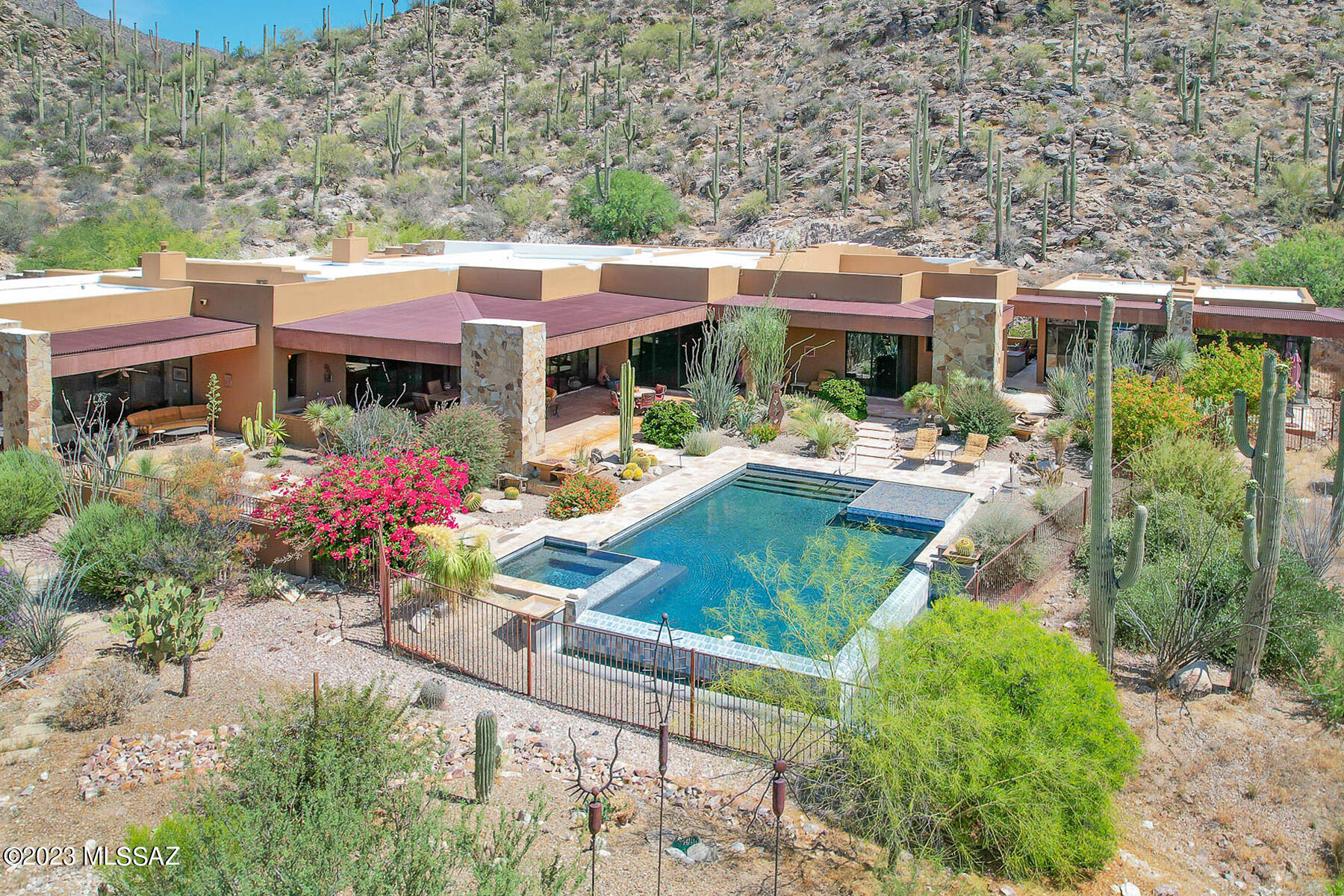 Stunning mountain views surround this beautiful SW Contemporary home on over 4 acres of saguaro studded desert and offering complete privacy. Living room with complete bar and wine cellar, guest house with living rm, bedroom and kitchen, master suite with large walk in closet, his and her bathrooms and separate exercise room. Family room off kitchen with butlers pantry, office w/built-ins and media room. Numerous patio's and entertainer's dream areas surround the pool and spa, outdoor kitchen/BBQ. 6 car garage.