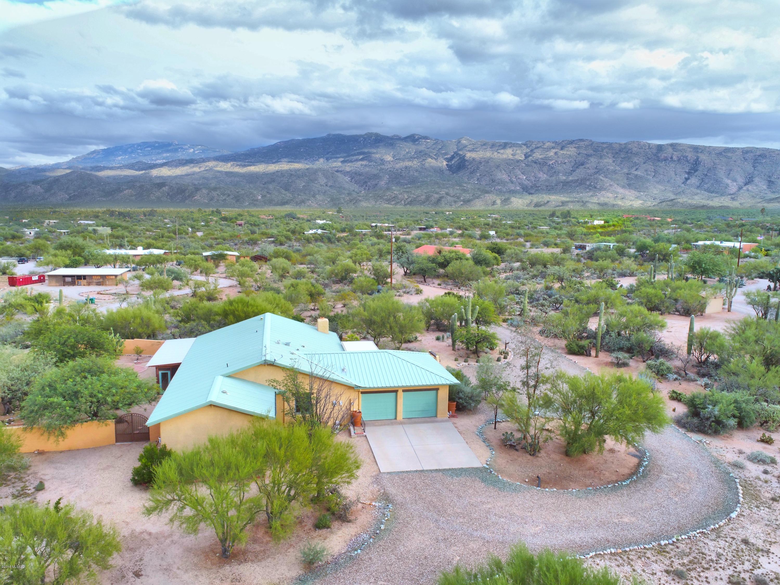 Equestrian property in the desirable ''notch neighborhood.'' Fantastic horse trails just minutes away. Beautiful views of the Rincon and Catalina mountians from this lush and private 4.53 acre lot. Extensive Horse facilities on property for easy boarding. The home boast of charm and upgraded appointments. Open, bright and welcoming. Large kitchen w/ granite counters, tile backsplash, alder wood cabinets w/ pull-outs, desk, and china hutch. SS appliances, kitchen Island, recess lighting and beautiful wood cased dual pane windows throughout. All doors are solid wood throughout with decorative and upgraded hardware. large walk-in closets with solid wood shelving. Large AZ room with mini split cooling, natural wood ceilings, ceiling fans, surround windows and 3 doors for easy access to backyar Separate mini kitchen in AZ room for outdoor entertainment. Beehive fireplace and large picture windows in living room.  Special touches throughout makes this home so charming! Each bathroom has separate Comode room with its own sink.  Beautiful walk-in shower in MB and Huge walk-in closet.  Wrought Iron gates and stucco walls create several separate patios with stunning view and lush vegetation. Central Vac and owned solar.  Well cared for home with all the right touches!