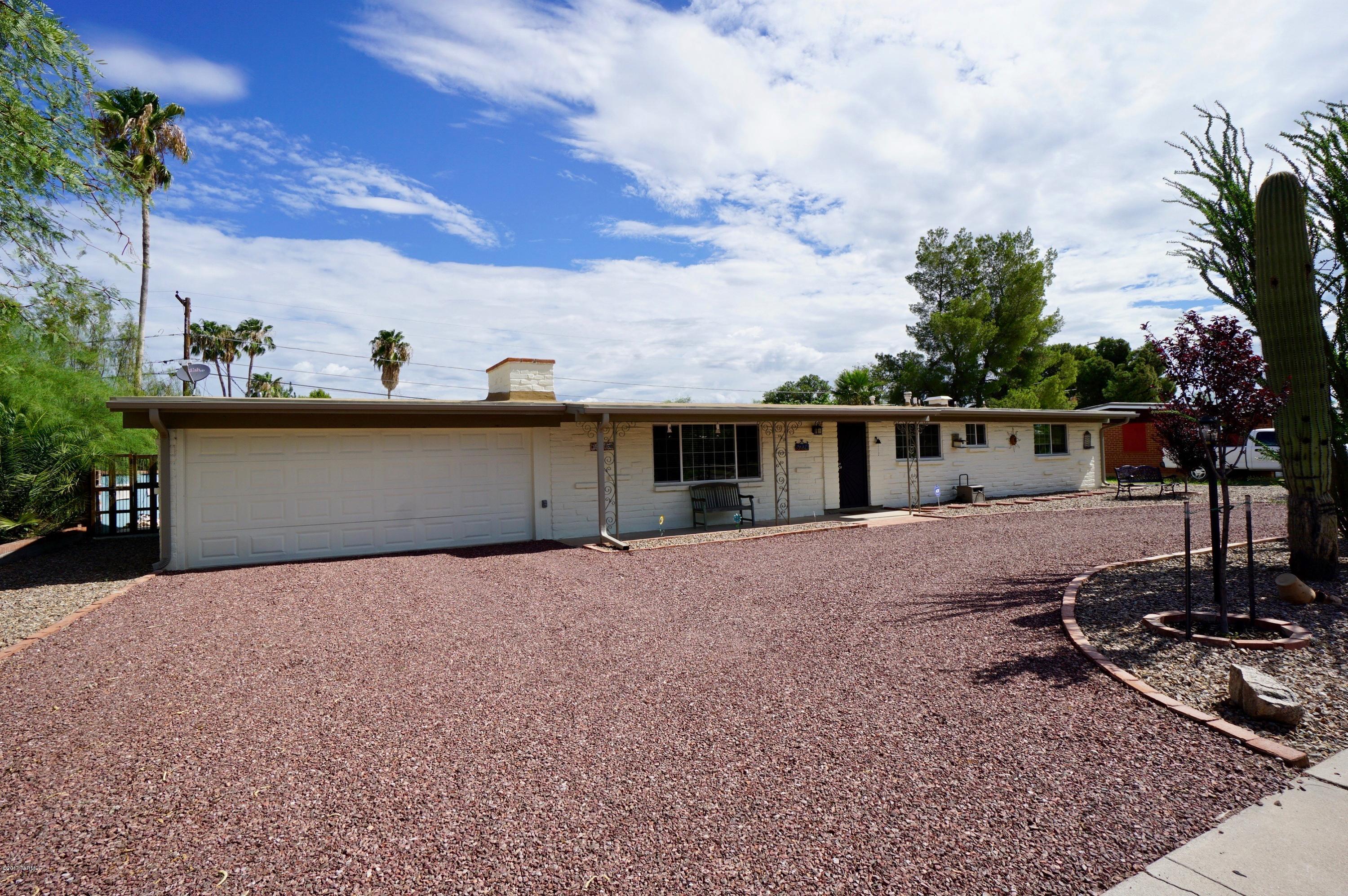 Beautifully updated burnt adobe ranch in great central location with 3 Bedroom/2 Bath, Den, Workshop and AZ Room. A circular driveway leads to this spacious home with a gorgeous kitchen with granite counters and stainless steel appliances. Living Room has an inviting fireplace and home has tile floors throughout with carpet in bedrooms. Large backyard with covered patio, mountain views, 2 car garage and even RV parking and drive through double gate.   Home has seamless gutters, new main water line, roof is 3 years old, low-e double pane windows, new insulation in ceilings, overhead lights and fans, and upgraded 200amp electrical.  Convenient to shopping, transportation and schools.