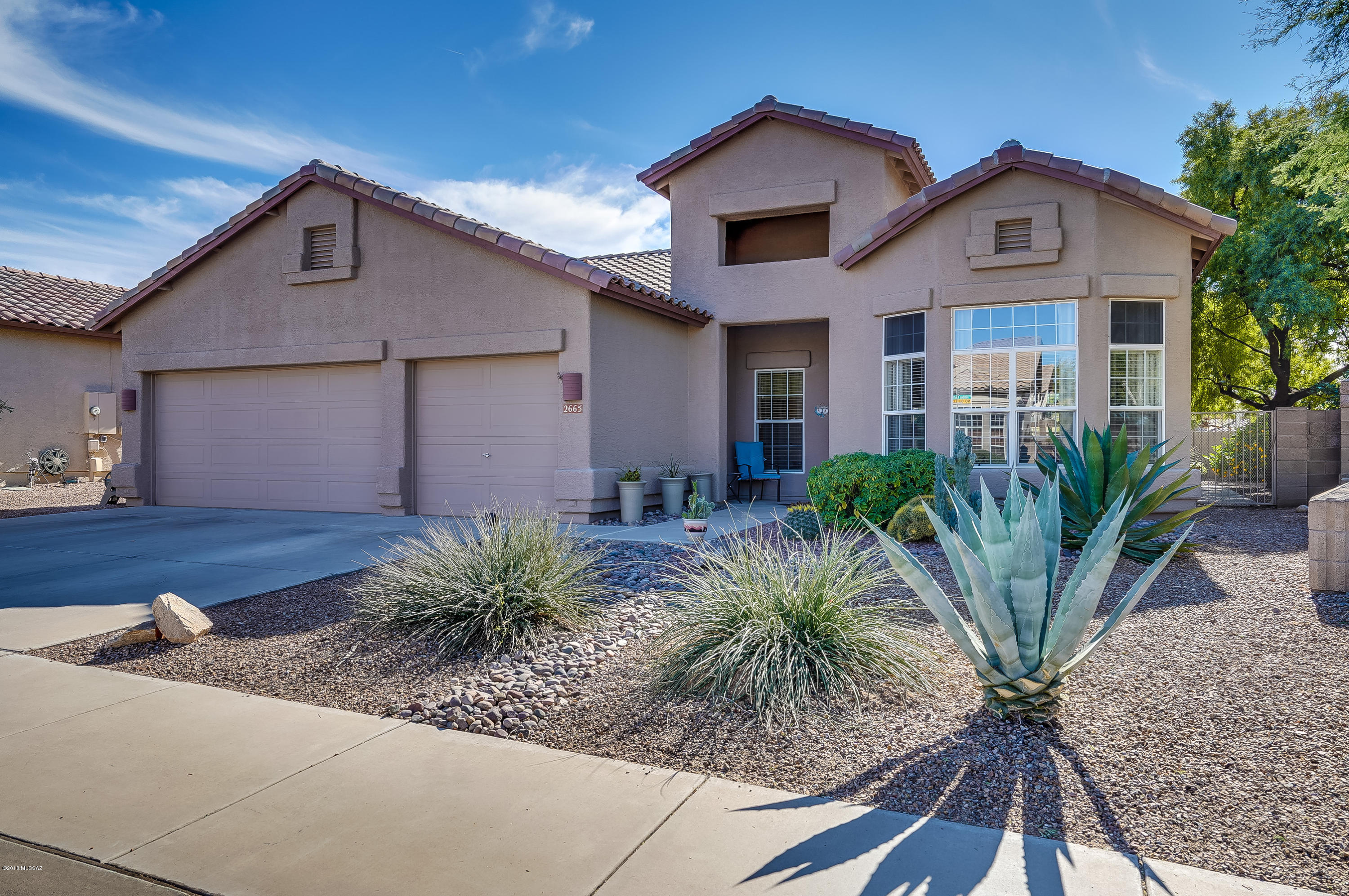 Exceptionally well-maintained beautiful home in popular Northwest The Bluffs Community.  2115 sft, 4 bedroom, 2 bathroom, 3 car garage with storage and workbenches.  Great natural light with cathedral ceilings and bay windows.  Home has no carpet: concrete floors, tile and laminate flooring.  Updated open concept kitchen with painted cabinets, granite countertop, tile backsplash and stainless-steel appliances.  Sparkling pool in landscaped back yard with mountain and sunset views.  High end lot next to lush park-like common area.  Great Room wall mounted LG TV, Sony receiver, (2) Bose speakers and black media cabinet convey. Come see this home before it's gone!