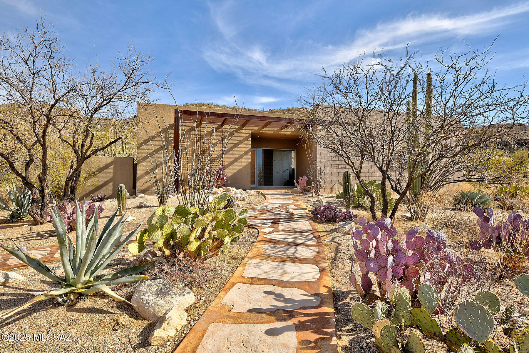 Nestled on 7.48 acres of pristine desert, this 4BD/2.5BA, contemporary masterpiece offers an unparalleled blend of luxury, privacy and breathtaking city & mountain views. Enjoy indoor-outdoor living with a disappearing sliding glass door & solar heated pebble tec relaxation pool & spa.  2,480 SqFt home boasts an Arizona Designs kitchen & windows that frame the surrounding landscape like a work of art. Whether you're cooking in the gourmet kitchen or simply enjoying the tranquility of nature, every detail of this home is designed to inspire. Motorized television lift with remote, motorized shades on the picture windows & Bose music system. Polished concrete floors, security alarm & fire sprinkler system throughout. Experience the best of desert living, modern elegance & unmatched serenity. Wake up to golden sunrises over the Catalinas and unwind beneath a blanket of stars, all from the comfort of your own private retreat.
