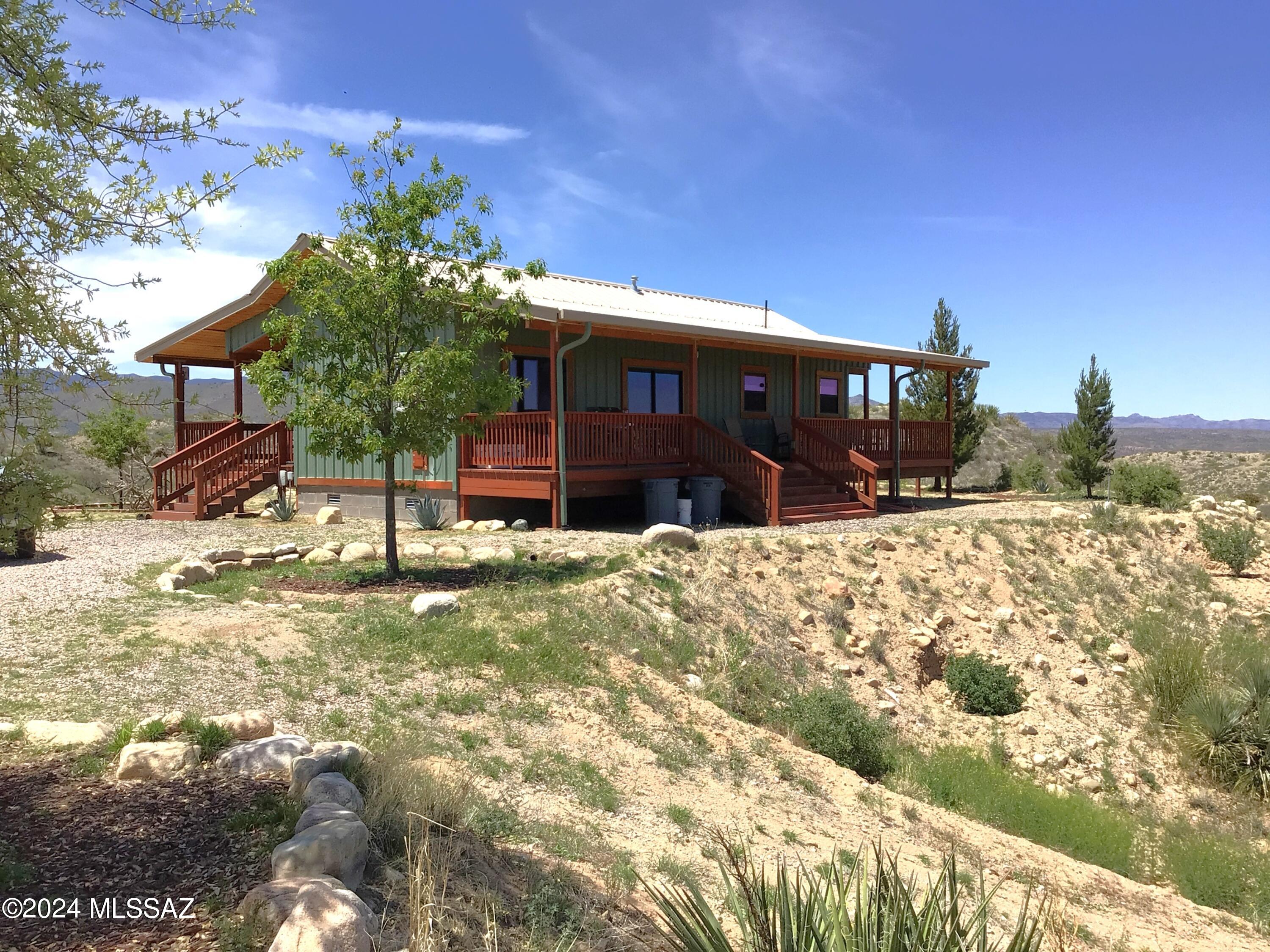 Off-grid living at its finest. 36.07 acres completely fenced with a solar gate at road leads to the 2-bedroom, 1-bath 960 sq ft house with an open concept living room, dining area, kitchen and office/den room. Solar panels w/battery storage to supply electric to all the appliances. Fiber-optic Internet & antenna tv hookup. Private well with 2 storage tanks & a tankless water heater. Propane tank to supply propane for the refrig, cooking & wall heating unit. There is an Evap. Cooling System. The kitchen has a dishwasher, the bathroom has a washer. Enjoy beautiful views from the picture windows or from the 3/4 wrap-around porch. There is a work/storage shed with full electric & a well house that has a room ready to become a generator room if so desired. Come see everything this place has.