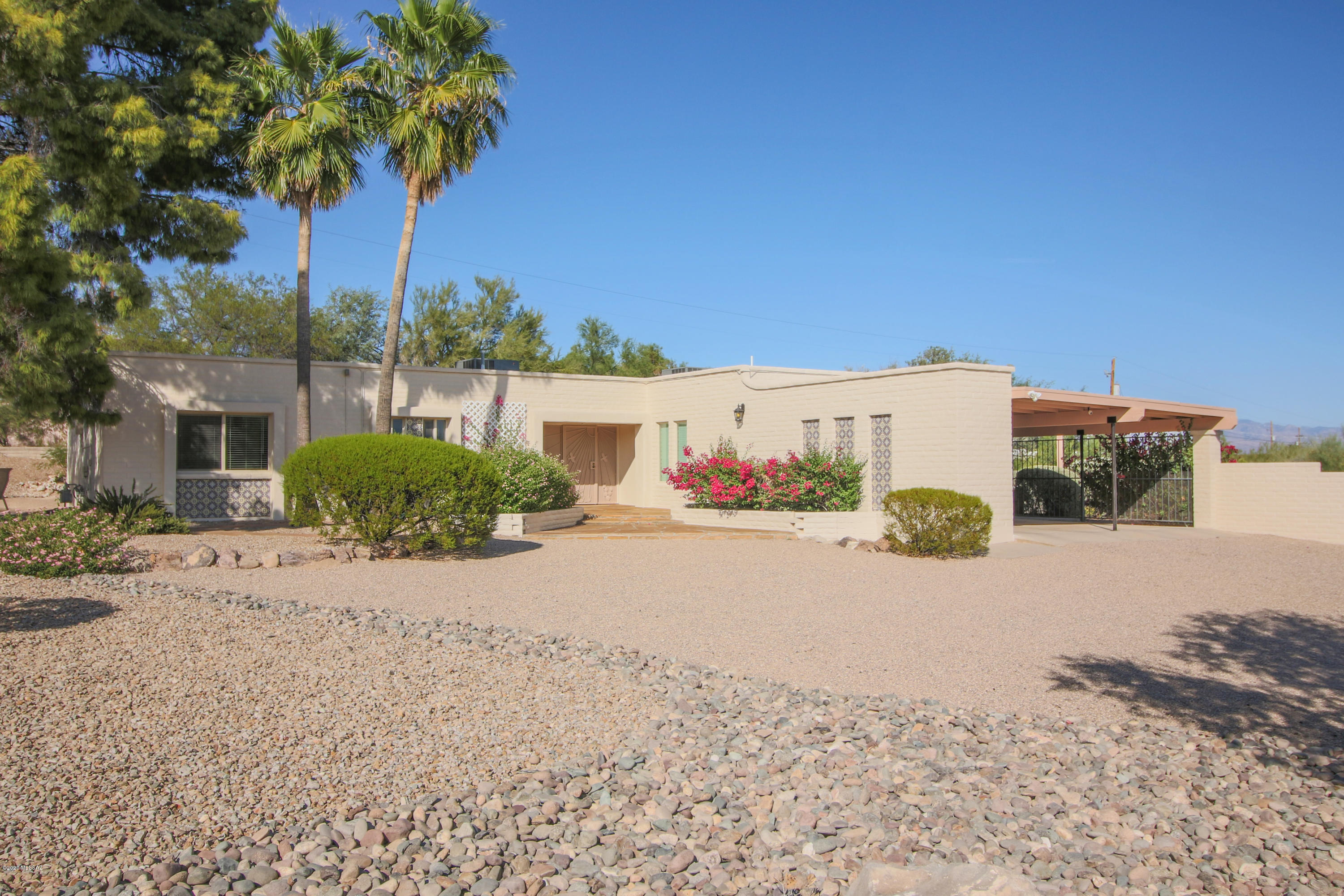 Welcome home.  Hacienda style entry to courtyard, home and parking. You feel the privacy as soon as you drive through the entrance. And you will feel the graciousness as soon as you enter the home.  Home has been meticulously detailed and is move-in ready. Beautifully updated kitchen with granite, appliances, paint, lighting, etc.  Newly updated guest bath and powder room.  Plenty of room to stretch out in the huge living room, and separate family room.  The backyard is an extension of the home, with full length covered patio, shrubbery, flowers, trees and views! Concrete basket ball court, free standing storage shed, and double gates.  Extra parking behind basket ball court would nicely accommodate an RV.