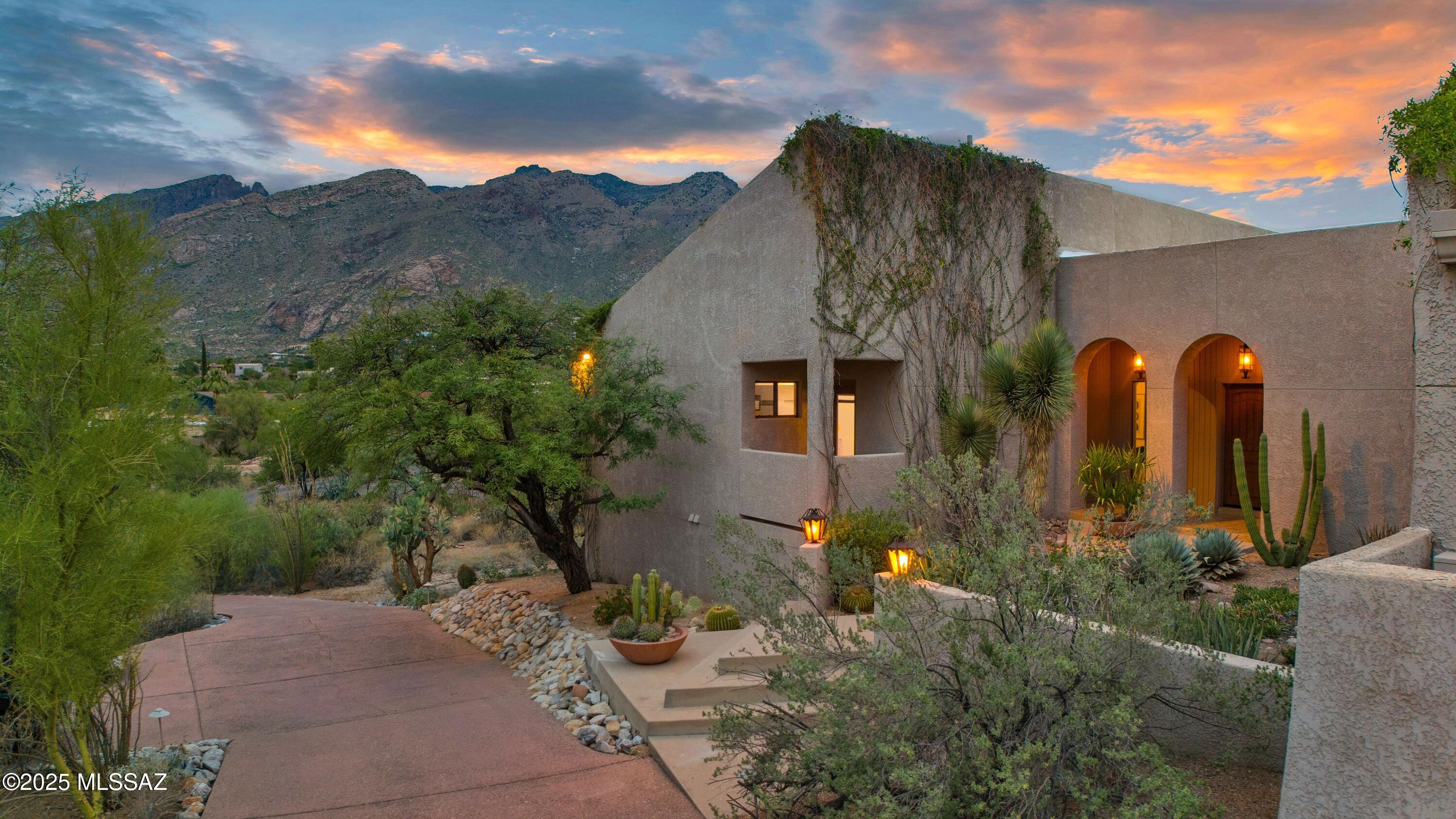 Move right into this  wonderful retro 1970's architect designed home surrounded by our beautiful desert and sitting on a hilltop with panoramic views of the city & sweeping views of the Catalina Mountains.  The very large kitchen may, indeed, be the heart of this home & if you love preparing food for those  special people in your life, this is the place to do it. And, dining may be on your south patio overlooking the pool & city lights or casual in the kitchen dining nook or more formal in the dining room. This is a home for comfortable living w/ the primary en suite on the main floor with mountain views and 5 more bedrooms; 2 baths on the lower level. The primary  also enjoys a covered porch that is the perfect place for watching fabulous Skyline CC fireworks High wood plank ceilings in the living areas & the large living room w/cozy fireplace opens to the porch for enjoying sunsets. as the sun sets & casts it's blues and pinks on the mountains. Personally, I love the cozy den that invites curling up with a good book & enjoying the city lights.. Plenty of room for the gym you've been dreaming of or the craft/sewing room. The long driveway to the top of the hill insures the quiet and privacy one dreams of. Tons of storage w/ plenty of walk-in closets & super storage in the garage along with a small workshop. There are so many ways to live in this lovely home. Just painted inside with new carpet & ready to move into & enjoy.