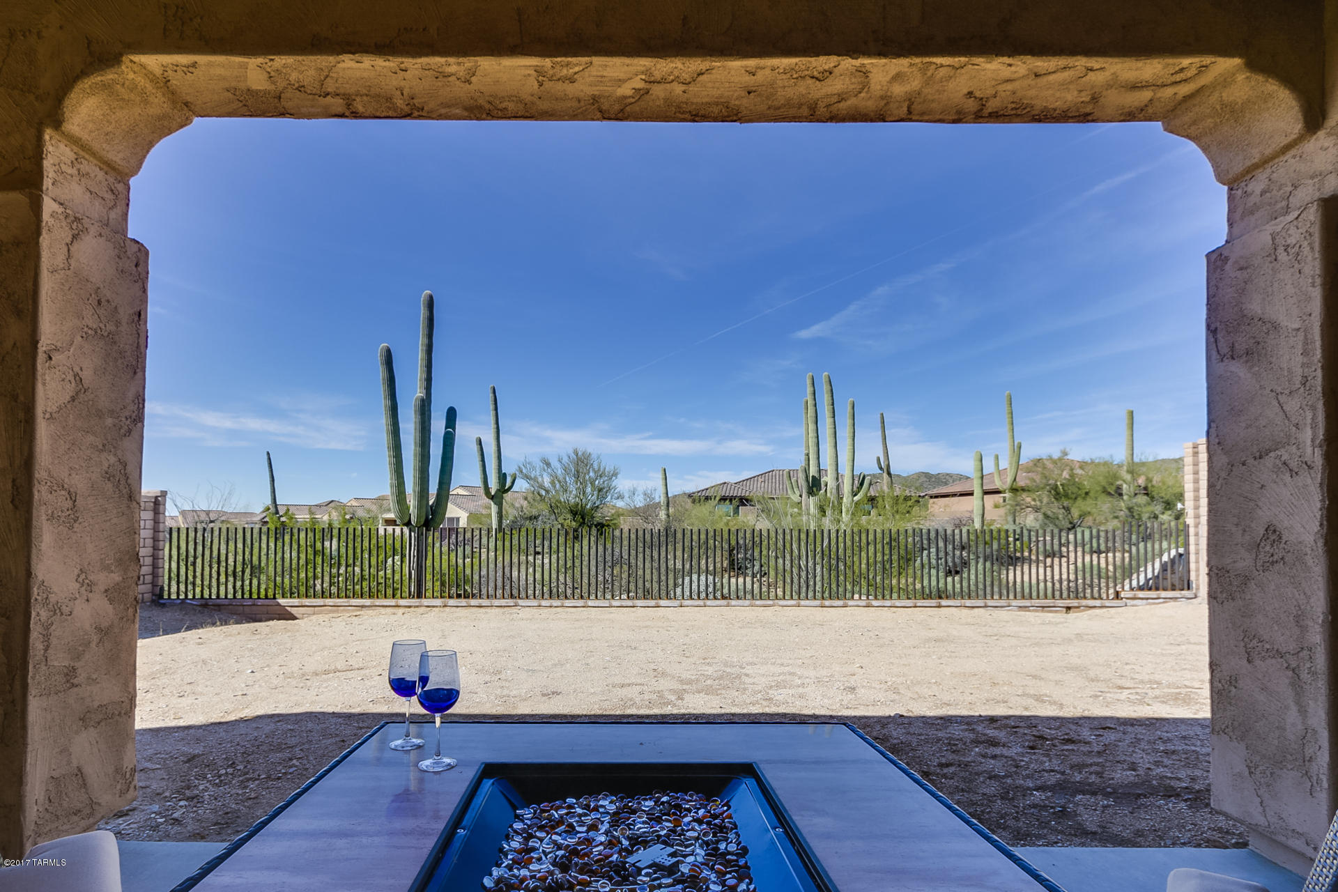 Enjoy this nearly new energy efficient home with Southwest flair in gated Los Saguaros on Dove Mountain. The split 4 Bdrm/3 Bath open floor plan features $20K+ upgrades including gourmet kitchen with SS appliances, double ovens, gas cook top, gorgeous granite countertops, staggered 42” cabinets w/crown molding, pull-out drawers & under-cabinet lighting.  Large kitchen island and dining extend to expansive great room & pocket dry bar for easy entertainment.  Custom lighting w/tile flooring in main living areas. Den/Office may be used as 5th Bdrm with walk-in closet. Relax in either the inviting front courtyard or extended back patio that overlooks Tortolita Mountains and multiple Saguaros in natural desert setting. Tandem 3 car garage. Home is still under warranty and a must see today!