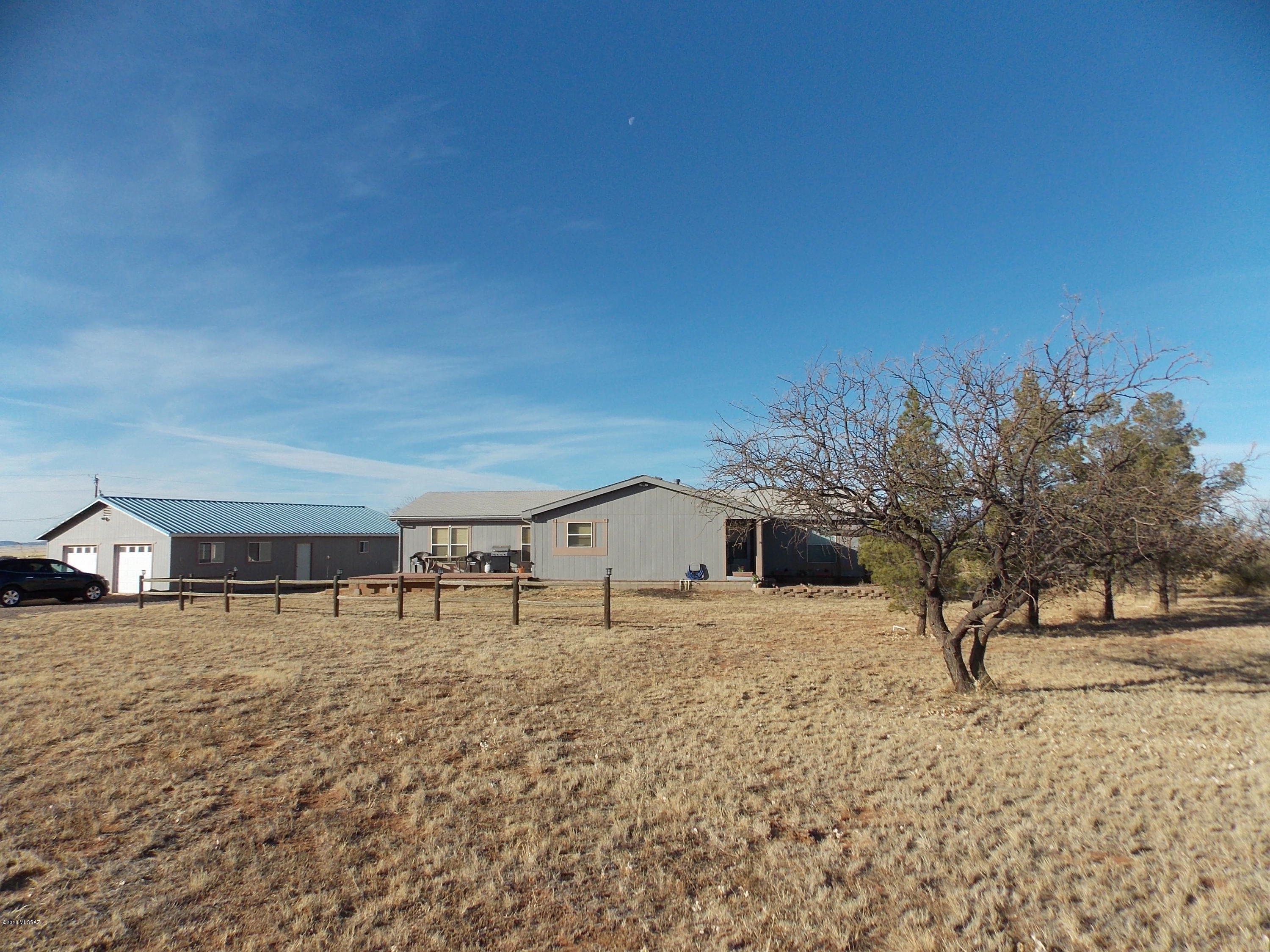 Breath taking views and amazing climate! Open floor plan manufactured home with a tag addition. 2177 sqft 3bd 2ba home on 5 acres. Private well, fenced with field fence, 1500sqft garage/workshop with an extra room and 2 roll-up doors, Kitchen has an eat-in area, a pantry closet, skylight and ample counter and storage space. The kitchen sliding glass door opens onto the deck for BBQs or just relaxing. No maintenance here the deck is made with composite boards, The front entrance is covered and has a nice garden area. Open great room feel with large living room, dining area. There is a separate area that could be used for a den/library/office/playroom. The spacious laundry room has a utility sink, storage closets and a doggie door. The master has a large walk-in closet, garden tub, separate Shower. It has a split bedroom layout with the other two room being spacious and having larger closets. The hall bath has a tub/shower combo. Come enjoy the wide open spaces, beautiful sunsets and amazing weather!