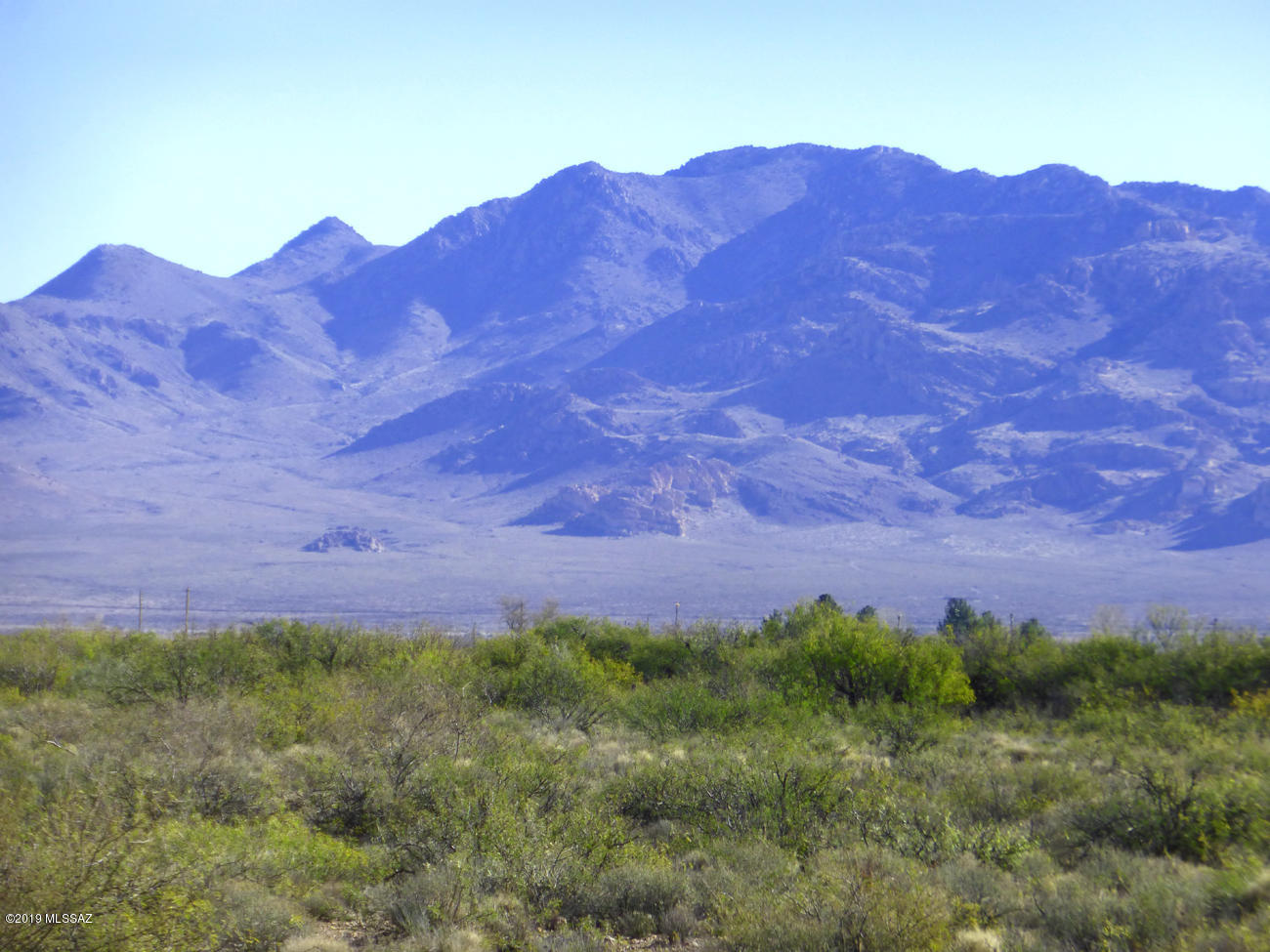 Long level parcel with power, DSL and phone on two sides, great mountain views of Portal Peak, and close to State Trust land. All-weather access from county-maintained paved W Portal Road & quiet county Mesquite Rd that runs right up to the Coronado National Forest, perfect for a quiet horseback ride at sunset. Fenced on two sides, and a nice little pond (local term is ''dirt tank'') that fills with runoff in monsoon season, ringed with mesquites that create a little wildlife sanctuary of your very own. State Trust land begins at the southwest corner. County lighting codes protect dark skies. No deed restrictions, manufactured home is fine. Historic CCC gabions trapped runoff for years; some good garden soil has built up there. 5 mi to Portal, 4 to Rodeo NM, post office, library, cafes.