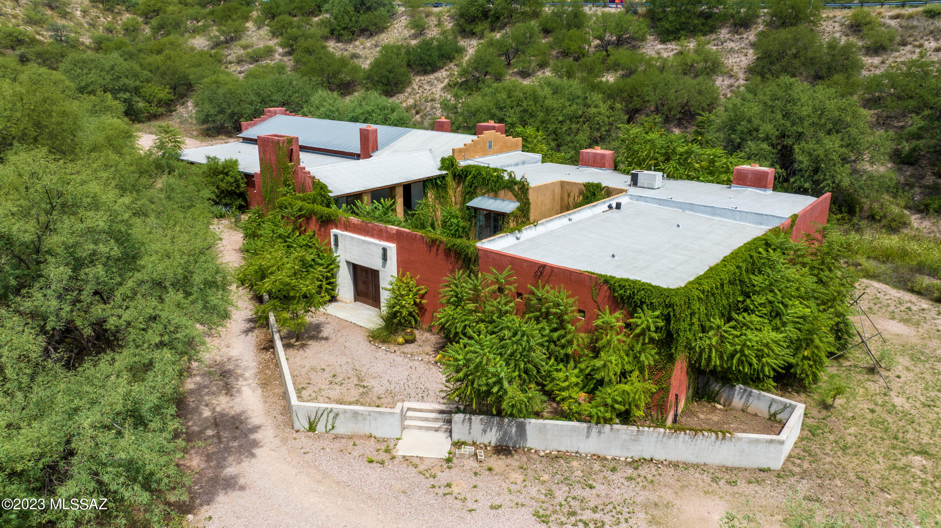 Welcome to this truly remarkable ''one of a kind'' property !! This home boasts 7645 sq. ft., one bedroom, 3 bathrooms, 6 fireplaces, high ceilings, scored concrete floors, library/den with handcrafted bookcases, steel custom built exterior doors. gorgeous enclosed  2300 sq. ft. Interior courtyard w/ custom built gates & luscious landscaping.....all on one acre!!  This hacienda was built by Charles E. ''Bud ''Holman II, a world renown American Expressionist Landscape Painter where he resided and painted in the various studios and galleries !!