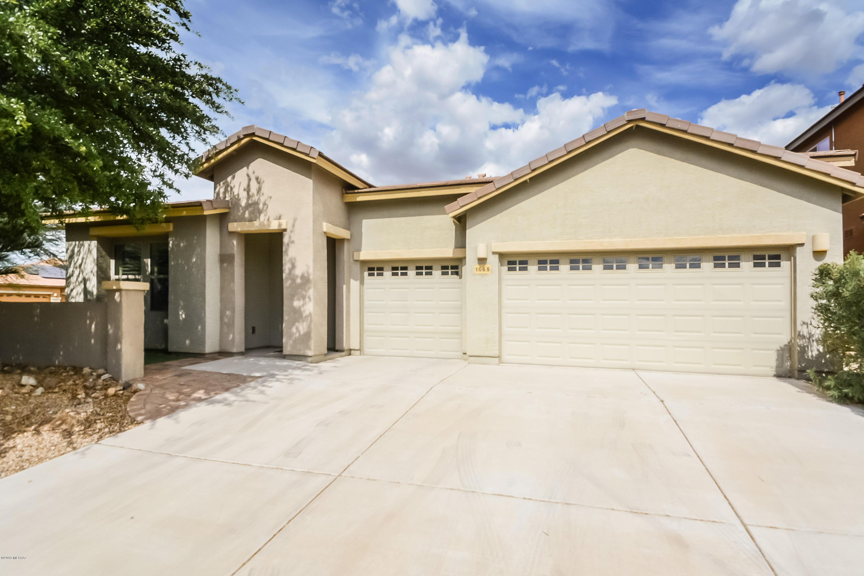 This Sahuarita one-story home offers a screen-enclosed covered patio, kitchen island with breakfast bar, master bathroom with separate tub and shower, and three-car garage.